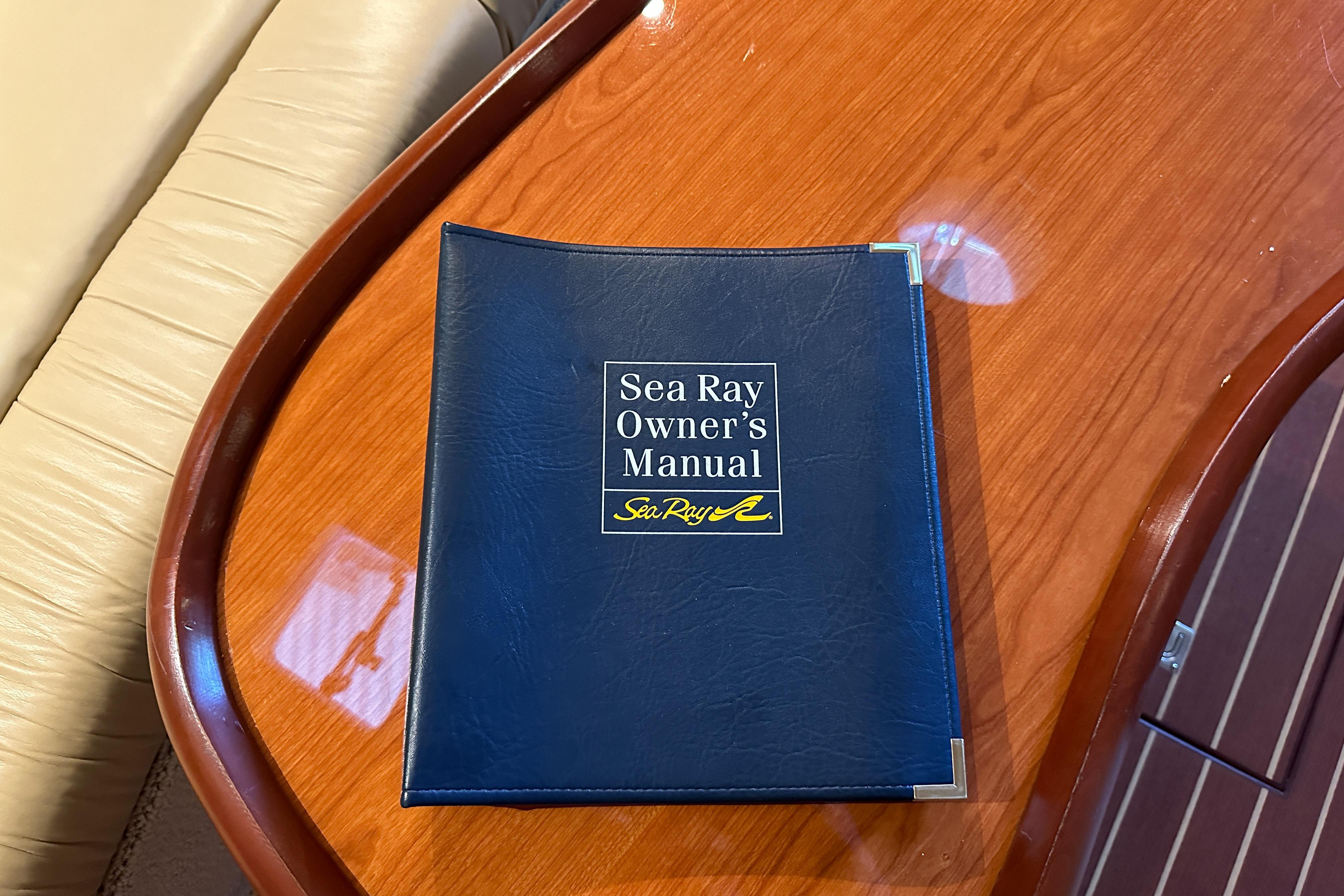 Sea Ray 410 Sundancer 2001 owner's manual on wooden table.