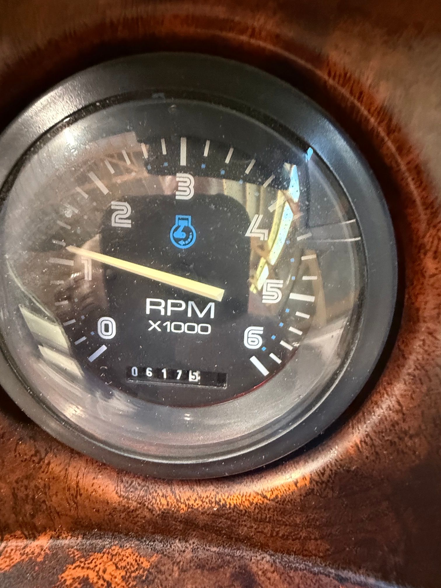 Close-up of a tachometer with wood trim, showing 617.5 revolutions.