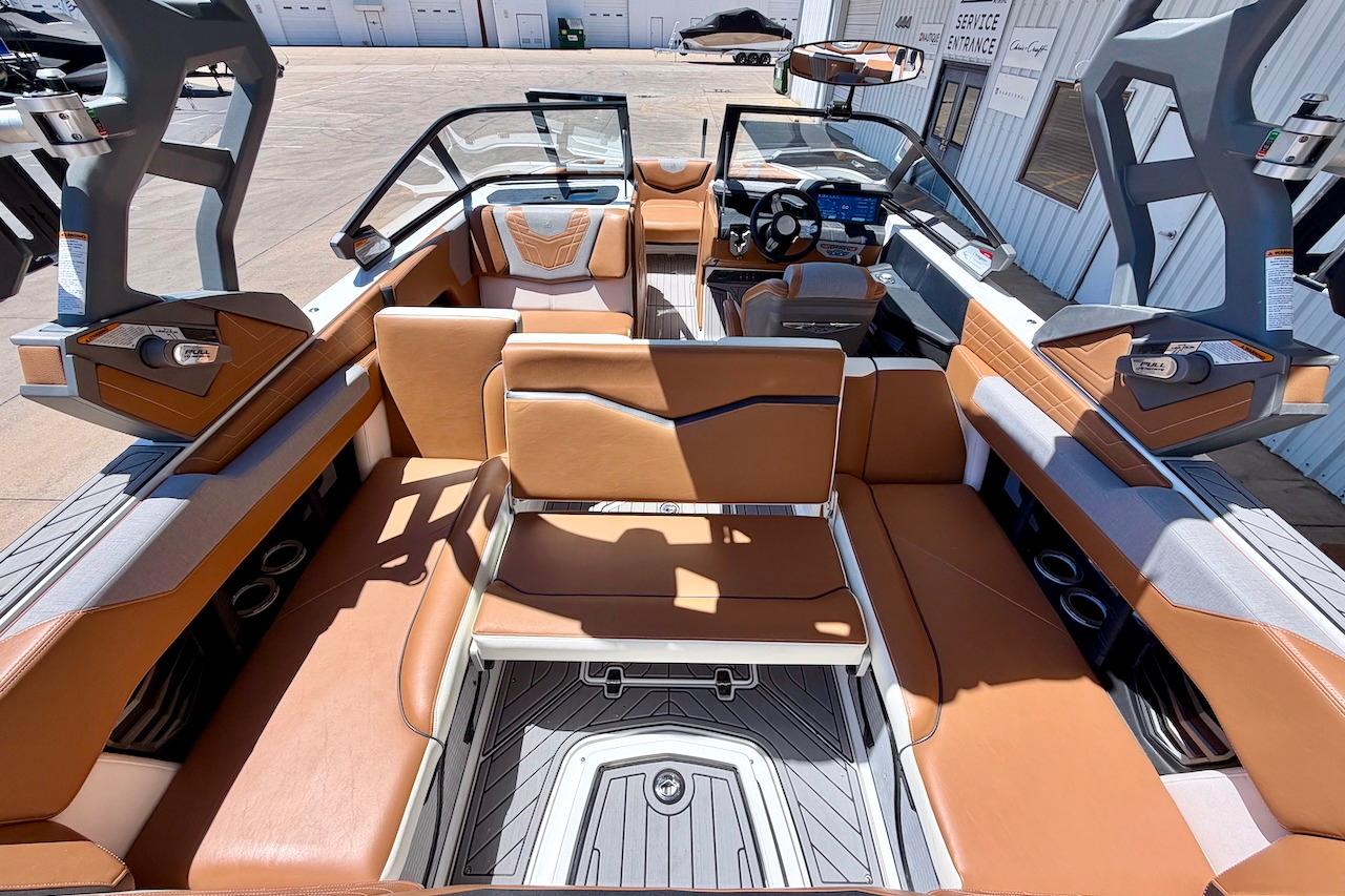 2021 Nautique Super Air Nautique G23 boat interior with tan leather seating and modern dashboard.