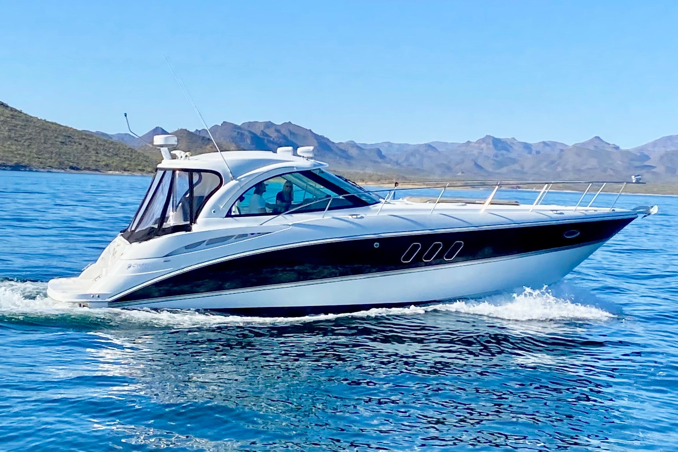 2011 Cruisers Yachts 390 Sports Coupe cruising on a serene blue lake.