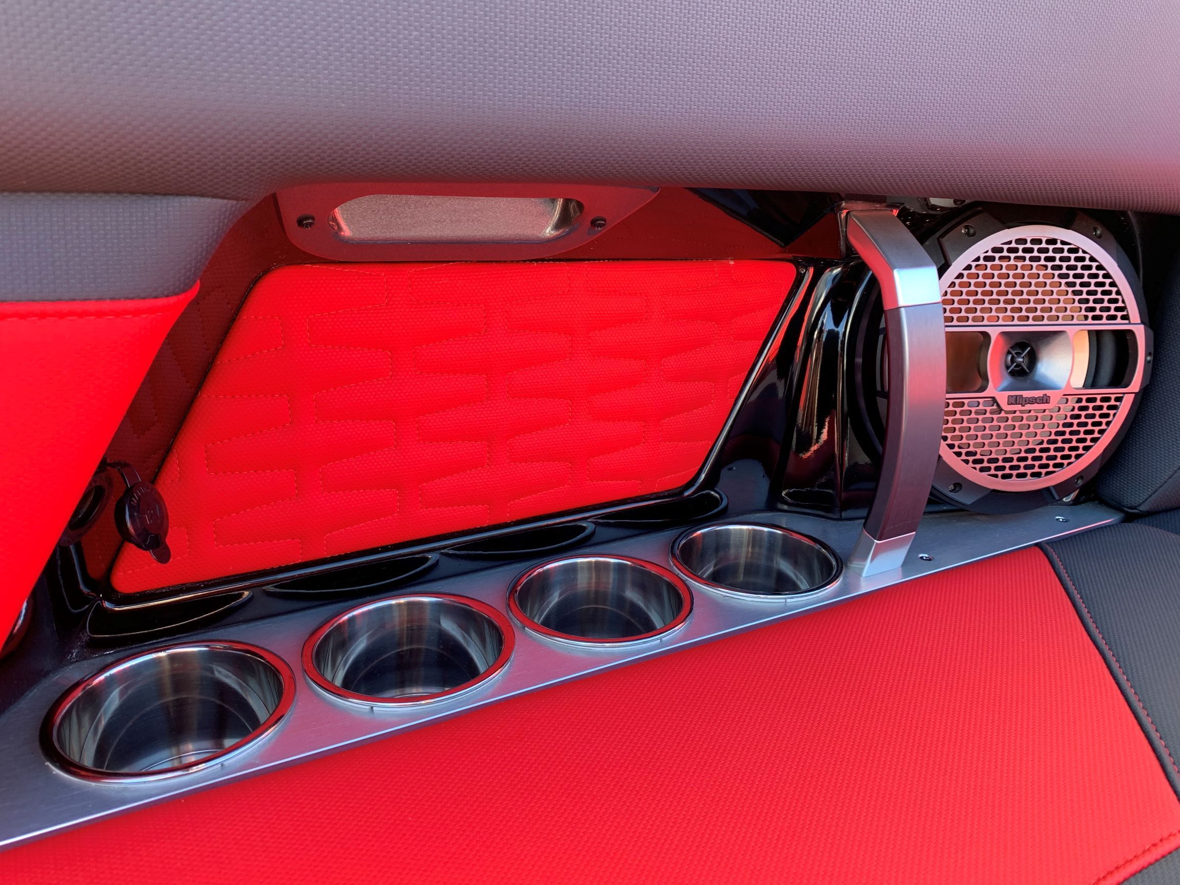 Close-up of a red boat interior with speaker and cup holders.