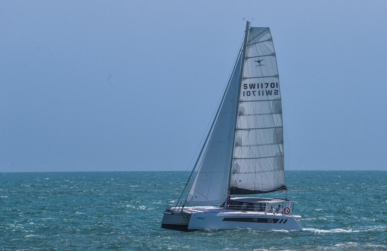 2025 Seawind 1170 catamaran sailing on open sea under clear blue sky.