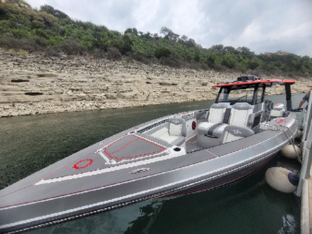 2024 Fountain 38 SCX boat docked by rocky shoreline.