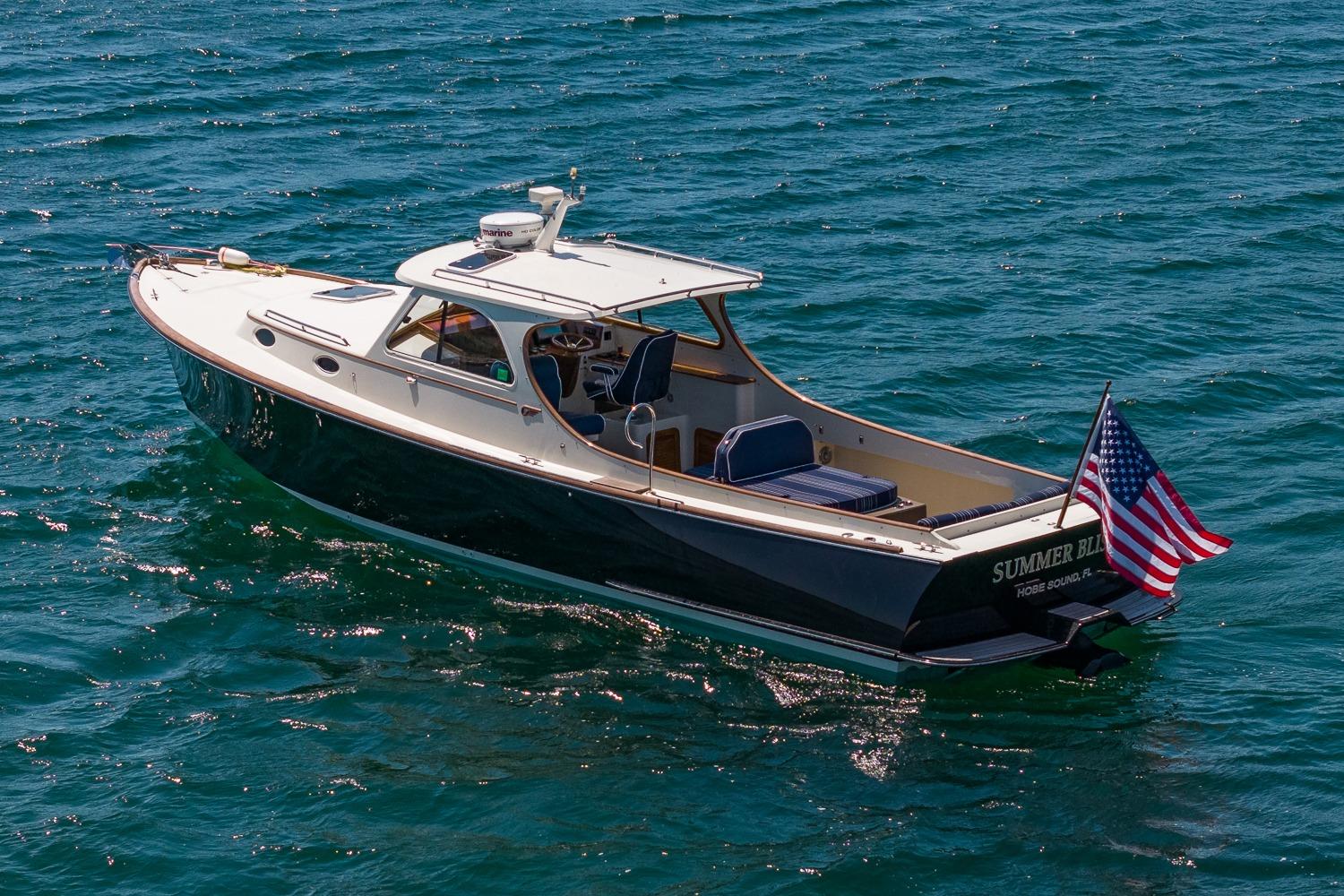2001 Hinckley Picnic Boat 36 Classic cruising on open water with American flag.