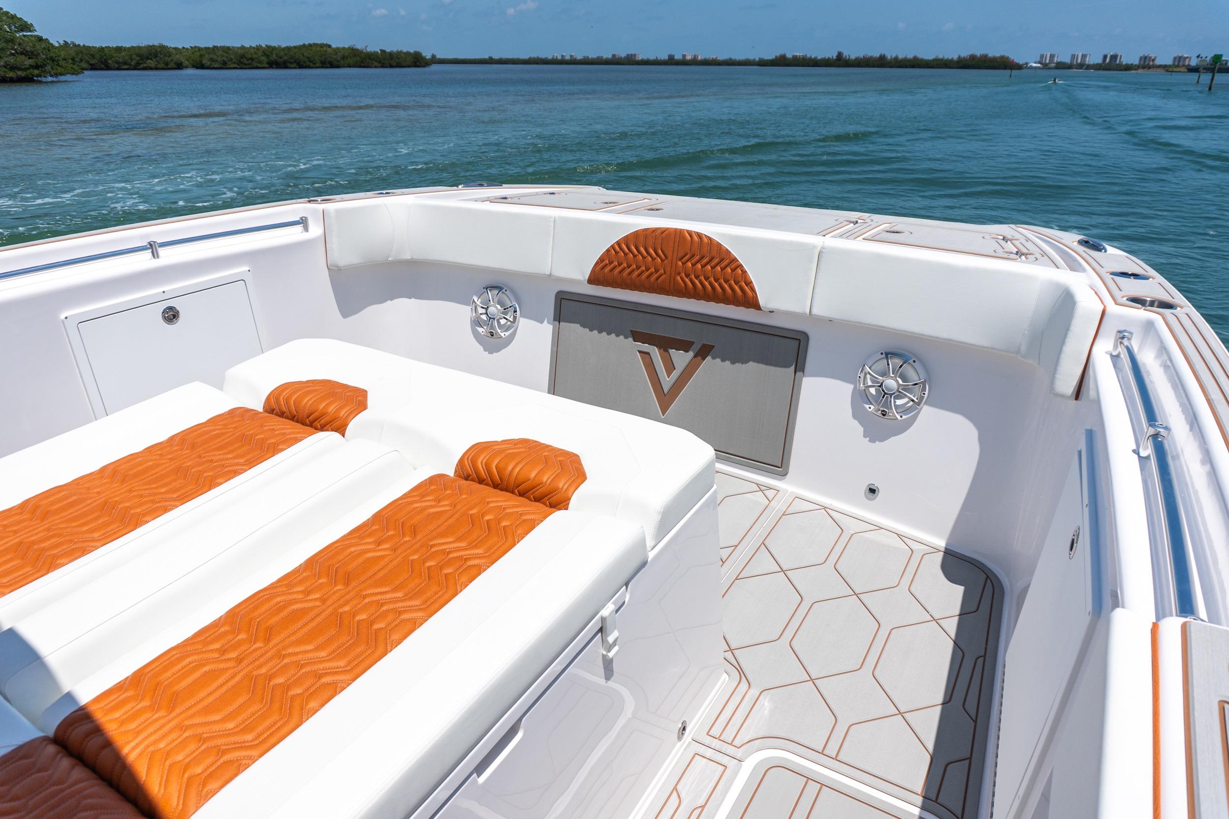 2026 Twin Vee 400 GFX2 CC boat interior with orange and white seating, on calm water.