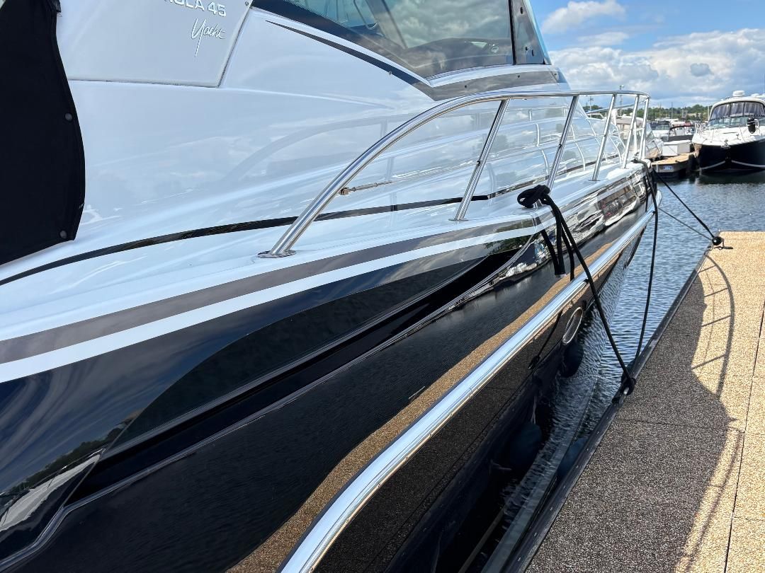 Side view of a 2011 Formula 45 yacht at the dock, featuring a sleek black hull and stainless steel railing.