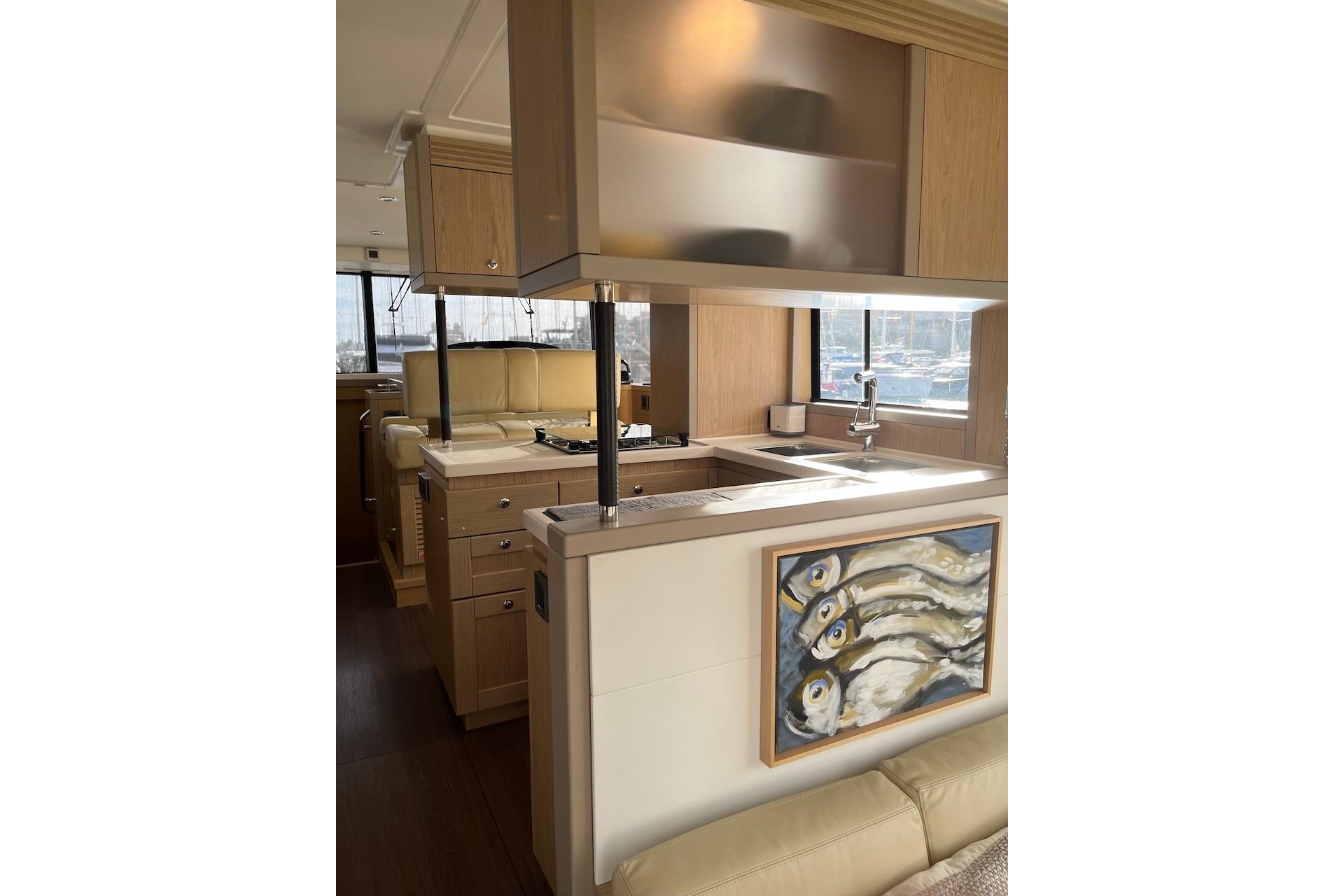 Interior of 2021 Beneteau Swift Trawler 50 with modern kitchen and fish artwork.