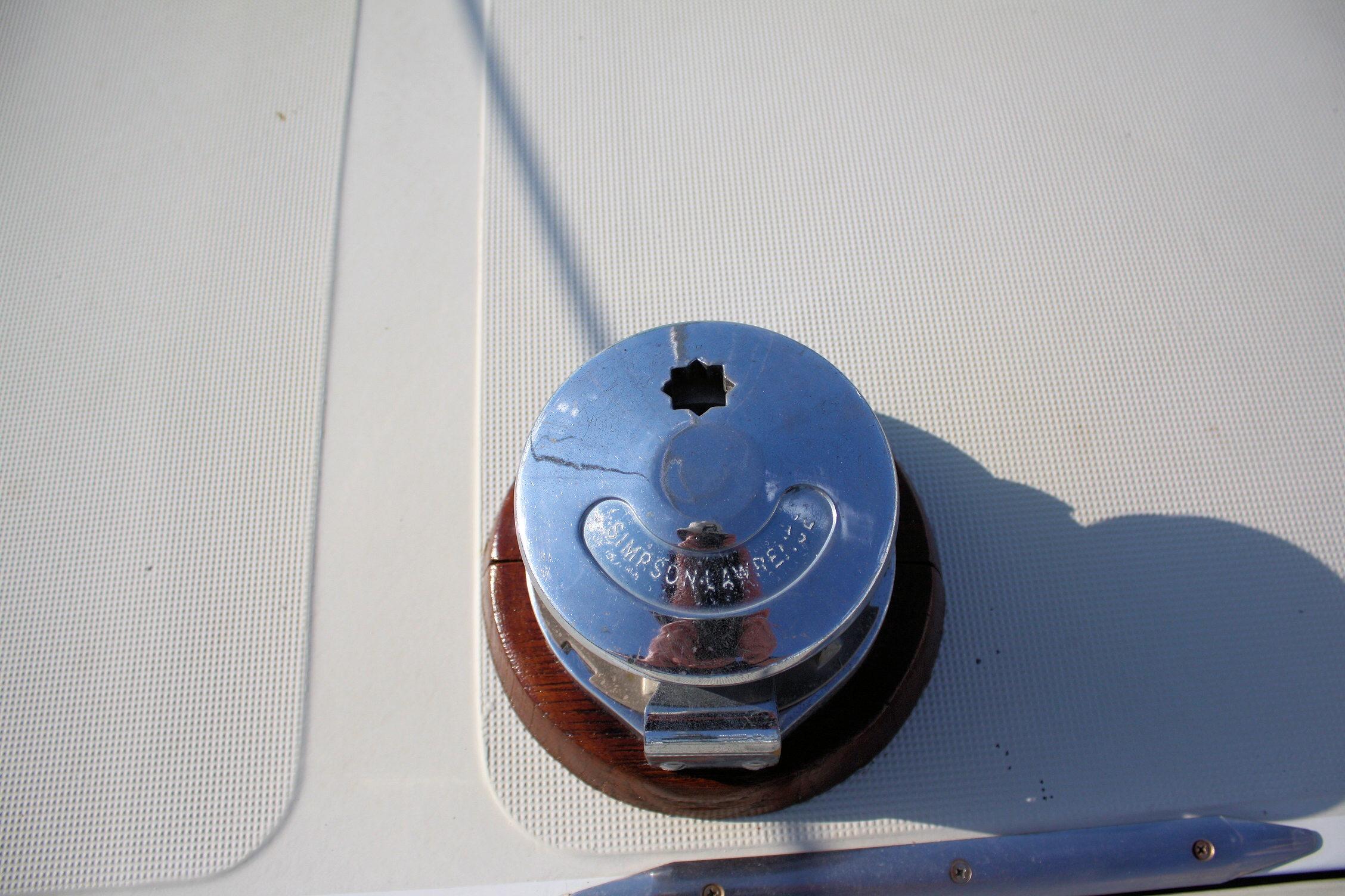 Chrome winch on 1987 Ericson 38-200 sailboat deck, reflecting sunlight.