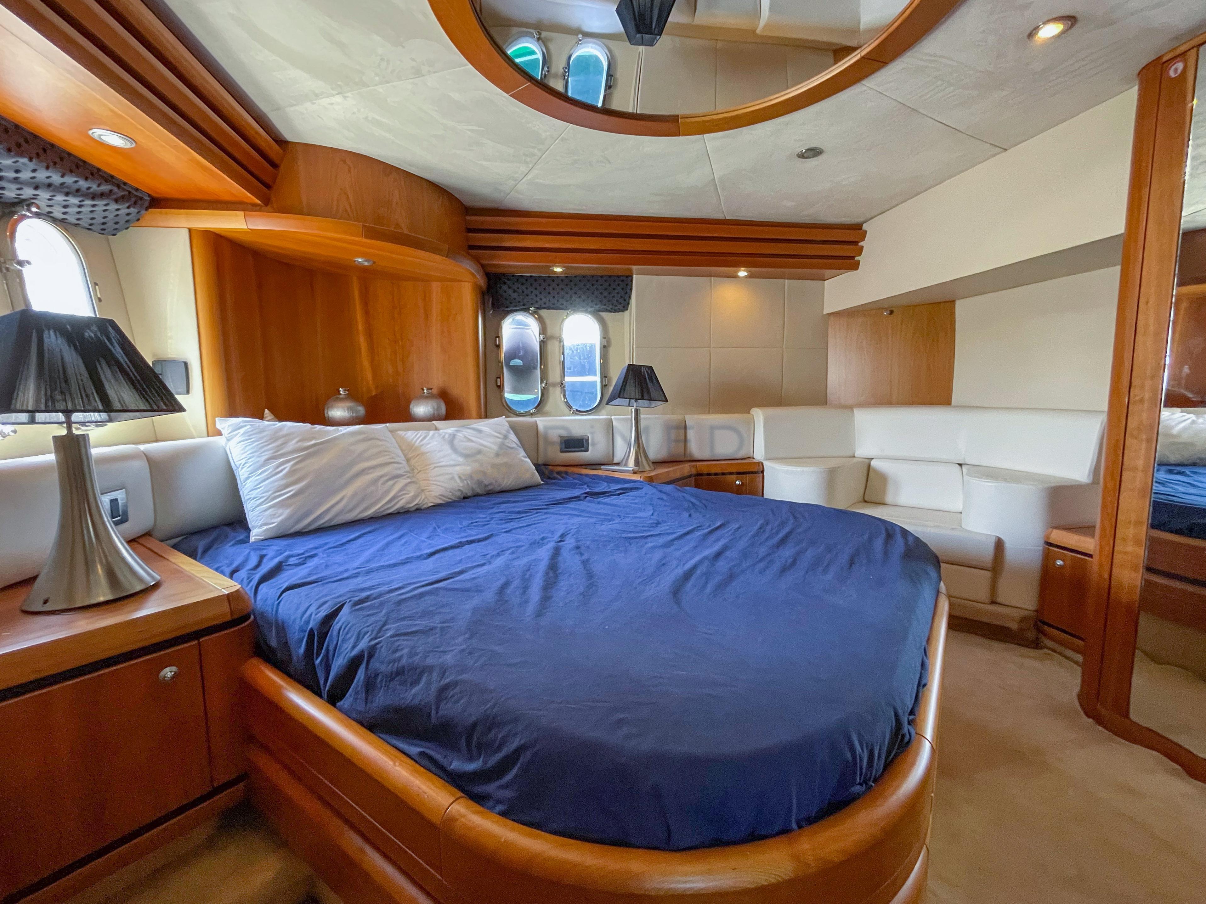 Luxurious bedroom interior of 2006 Pearl 60 yacht with elegant wood and plush furnishings.