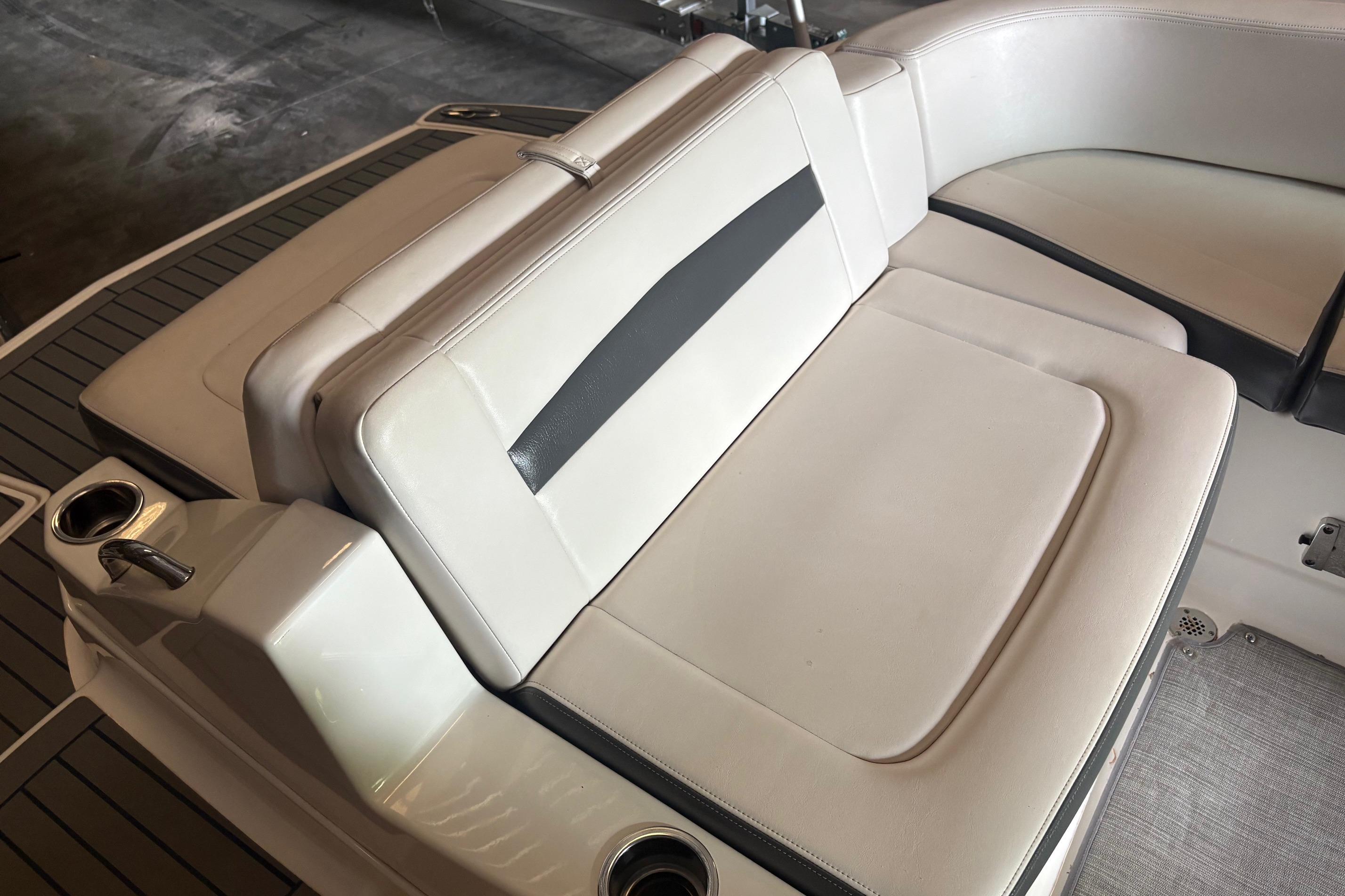 2016 Chaparral 244 Sunesta boat interior with white cushioned seating and cup holders.