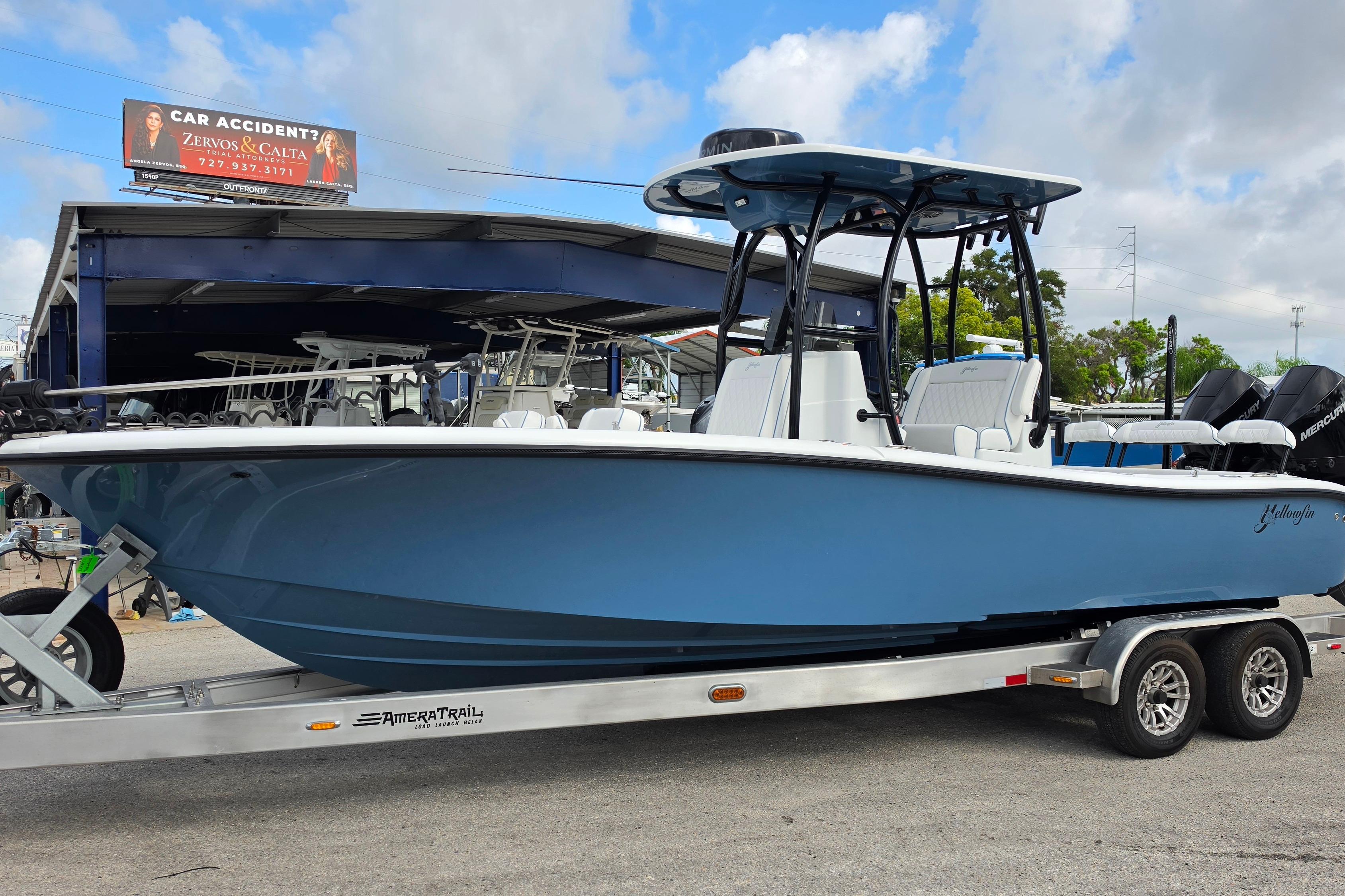 2025 Yellowfin 26 Hybrid boat on trailer, displayed outdoors under cloudy sky.
