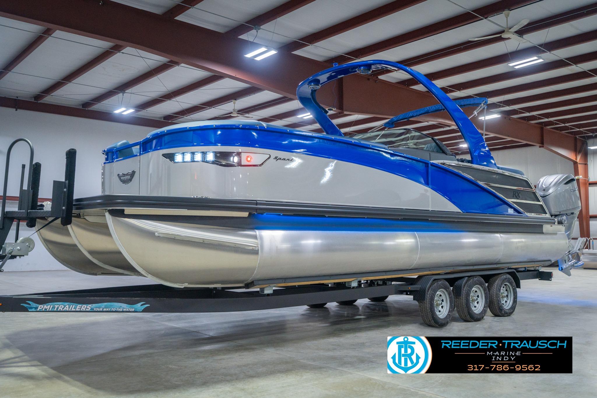 2026 Bennington 27 RX pontoon boat in showroom, blue and silver design, on trailer.
