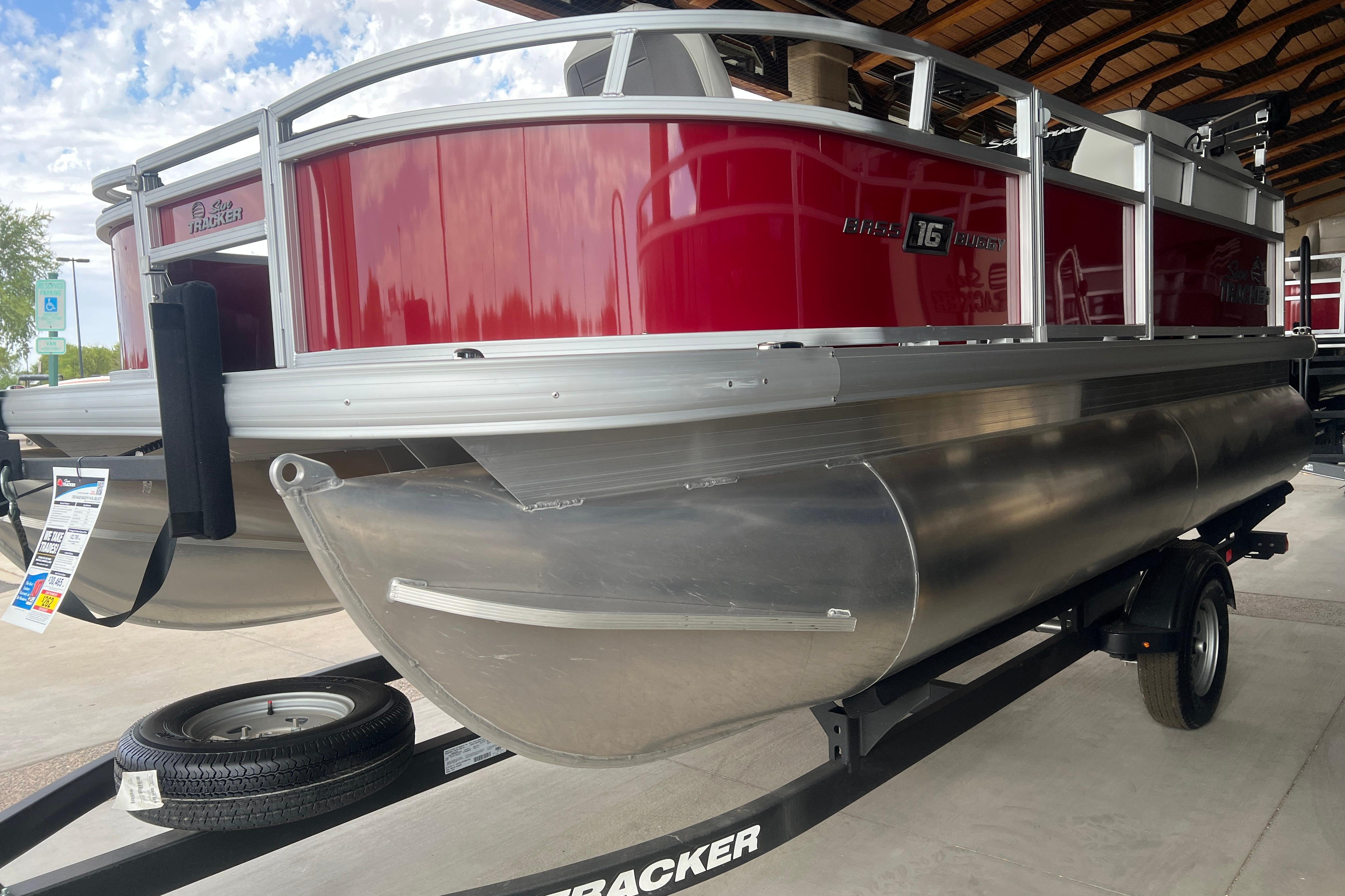 2026 Sun Tracker Bass Buggy 16 XL Select pontoon boat with red exterior.