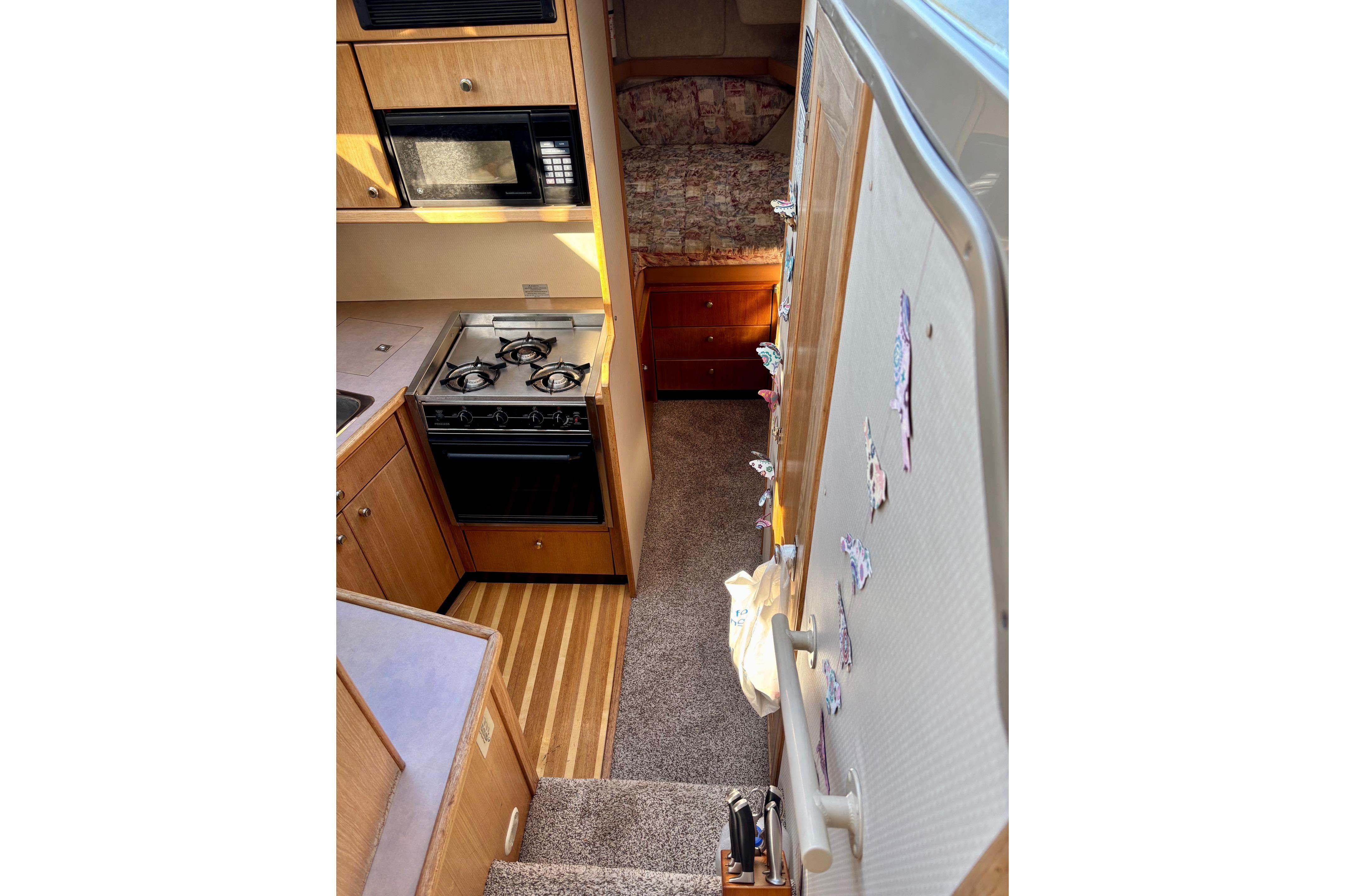 Interior of 1998 Bayliner 3388 Command Bridge Motoryacht with kitchen and cozy sleeping area.