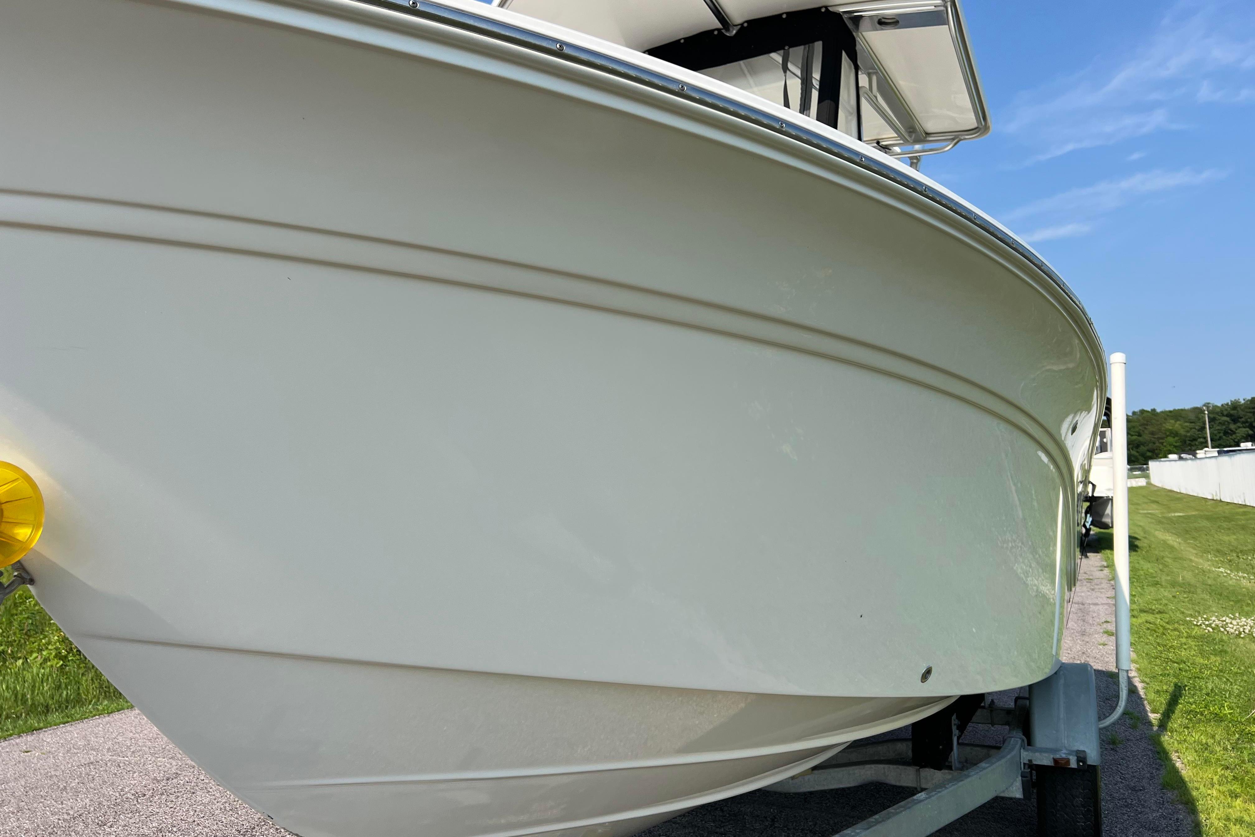 2012 Sea Fox 206 Center Console boat on trailer, side view under clear blue sky.