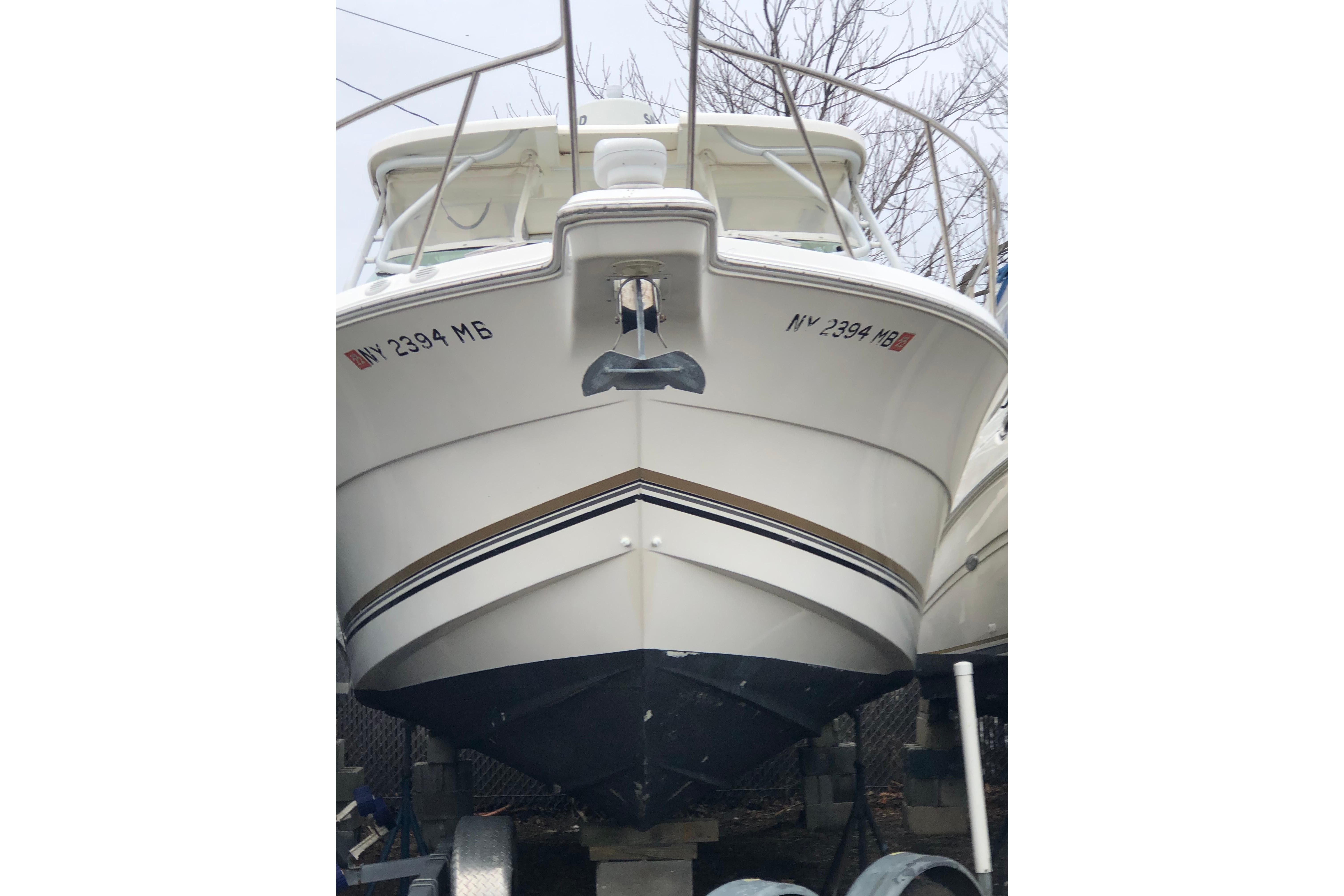 2004 Wellcraft 290 Coastal boat on trailer, front view, white hull with registration numbers.