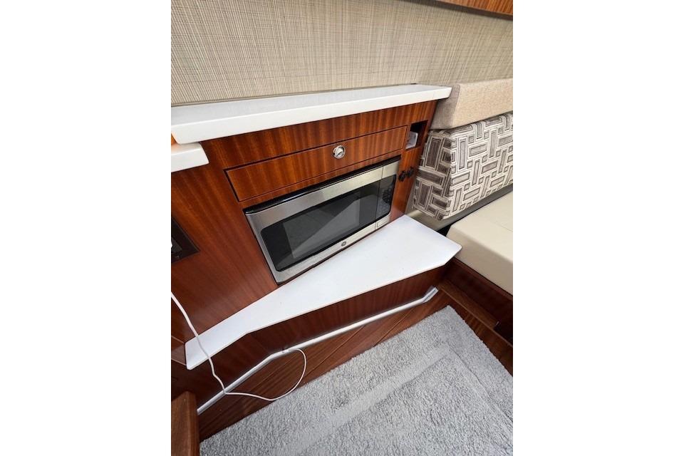 2023 Pursuit S 428 Sport interior with microwave and stylish wood finish.