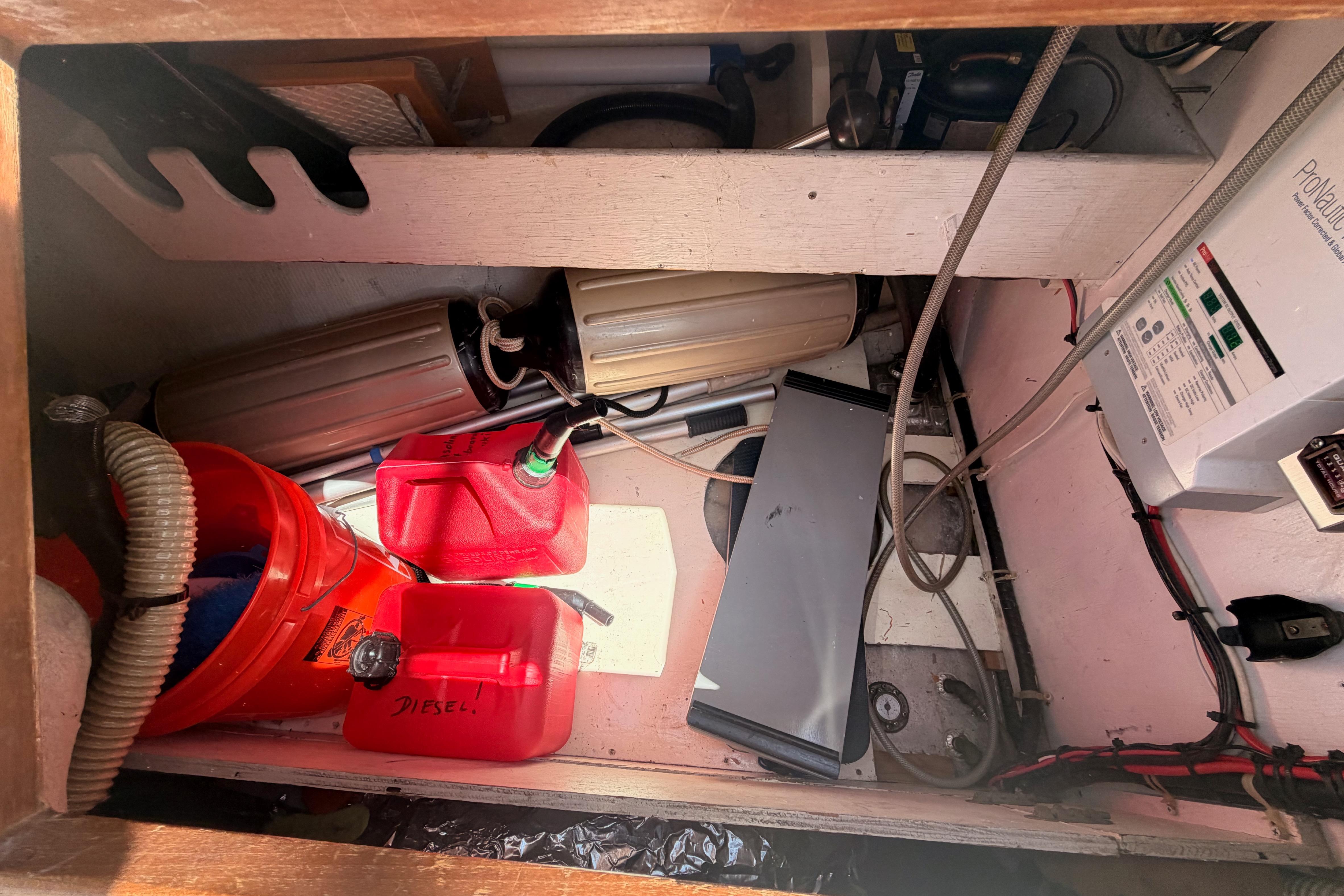 Storage compartment in a 1991 Caliber 33 boat with fuel containers and equipment.