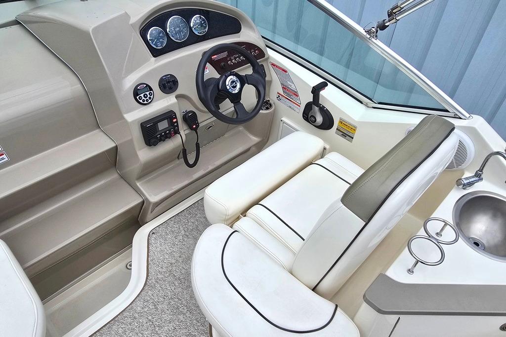 Interior view of 2006 Sea Ray 240 Sundancer boat cockpit with steering wheel and controls.