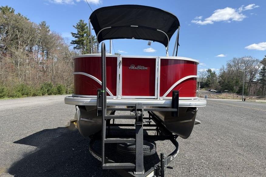 2026 Sun Tracker Party Barge 18 DLX pontoon boat on trailer, parked outdoors.