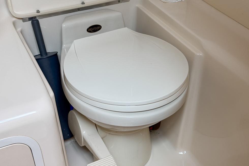 Marine toilet in 1999 Sea Ray 290 Sundancer boat, featuring compact design and white finish.