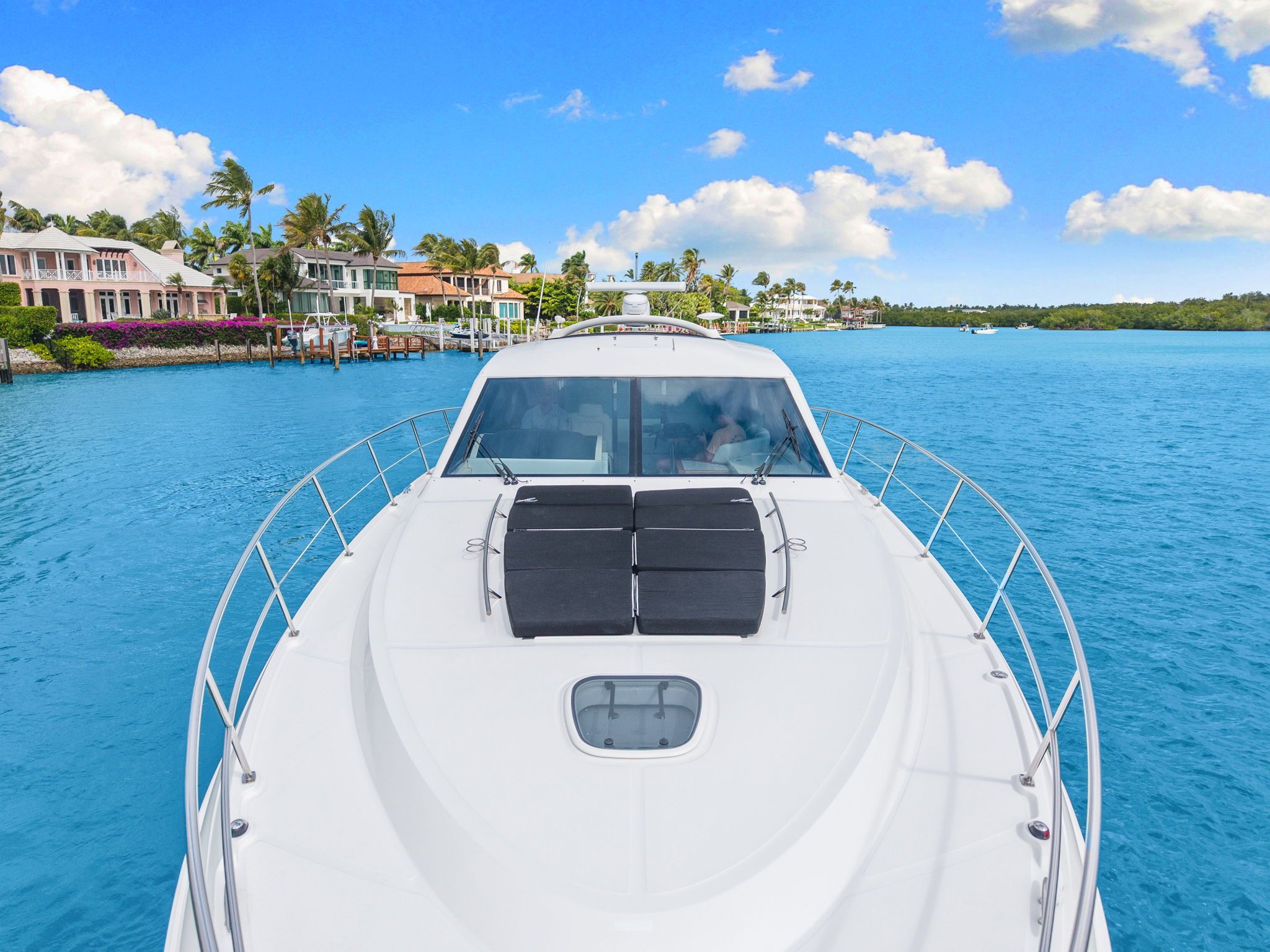 2017 Sea Ray Sundancer 510 on blue water with coastal houses in the background.