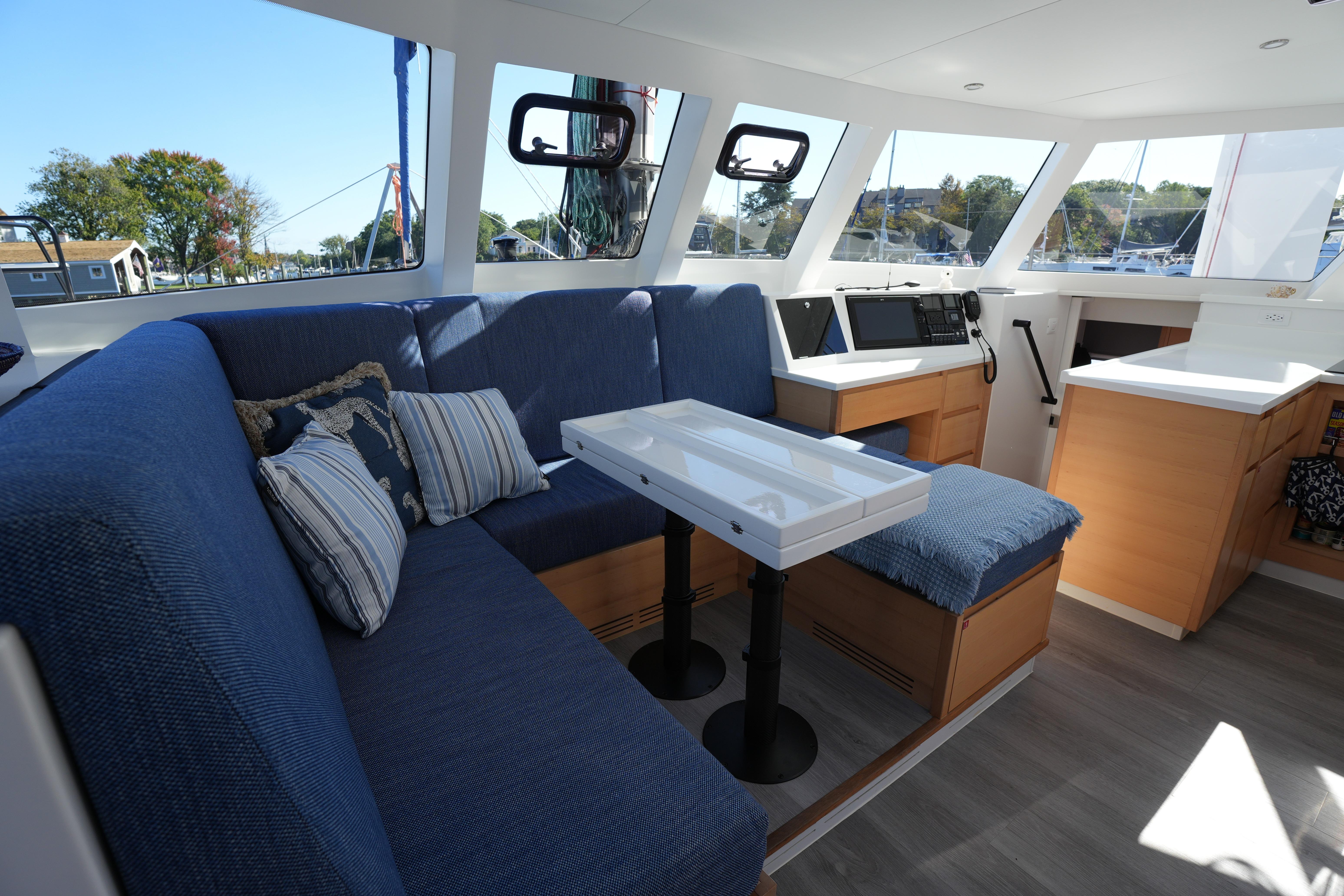 Interior of 2024 Balance 442 yacht with blue seating and modern navigation equipment.