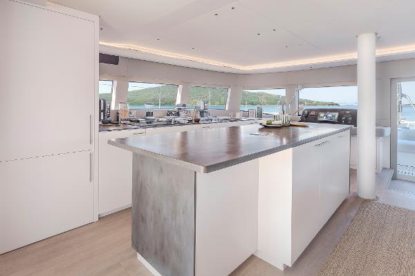 Luxurious interior of 2025 Lagoon SIXTY 5 yacht with modern kitchen and panoramic windows.