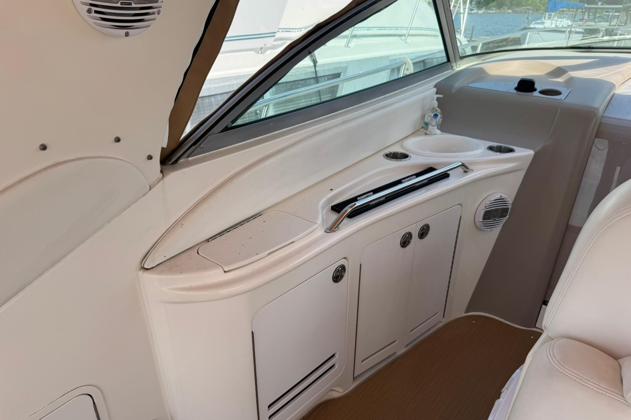 2001 Sea Ray 340 Sundancer interior with storage cabinets and cup holders.