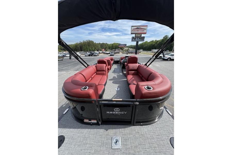 2026 Regency 230 DL pontoon boat with red seating and canopy, parked outdoors.
