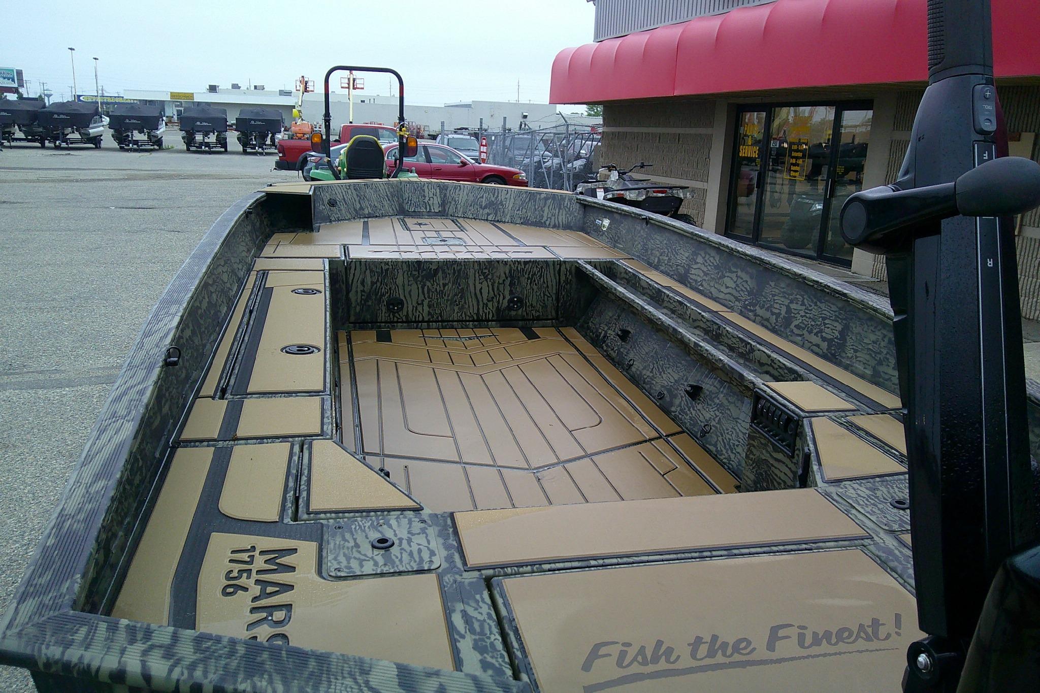 2026 Tracker Grizzly 1756 T Marsh boat with spacious deck, parked outside a dealership.