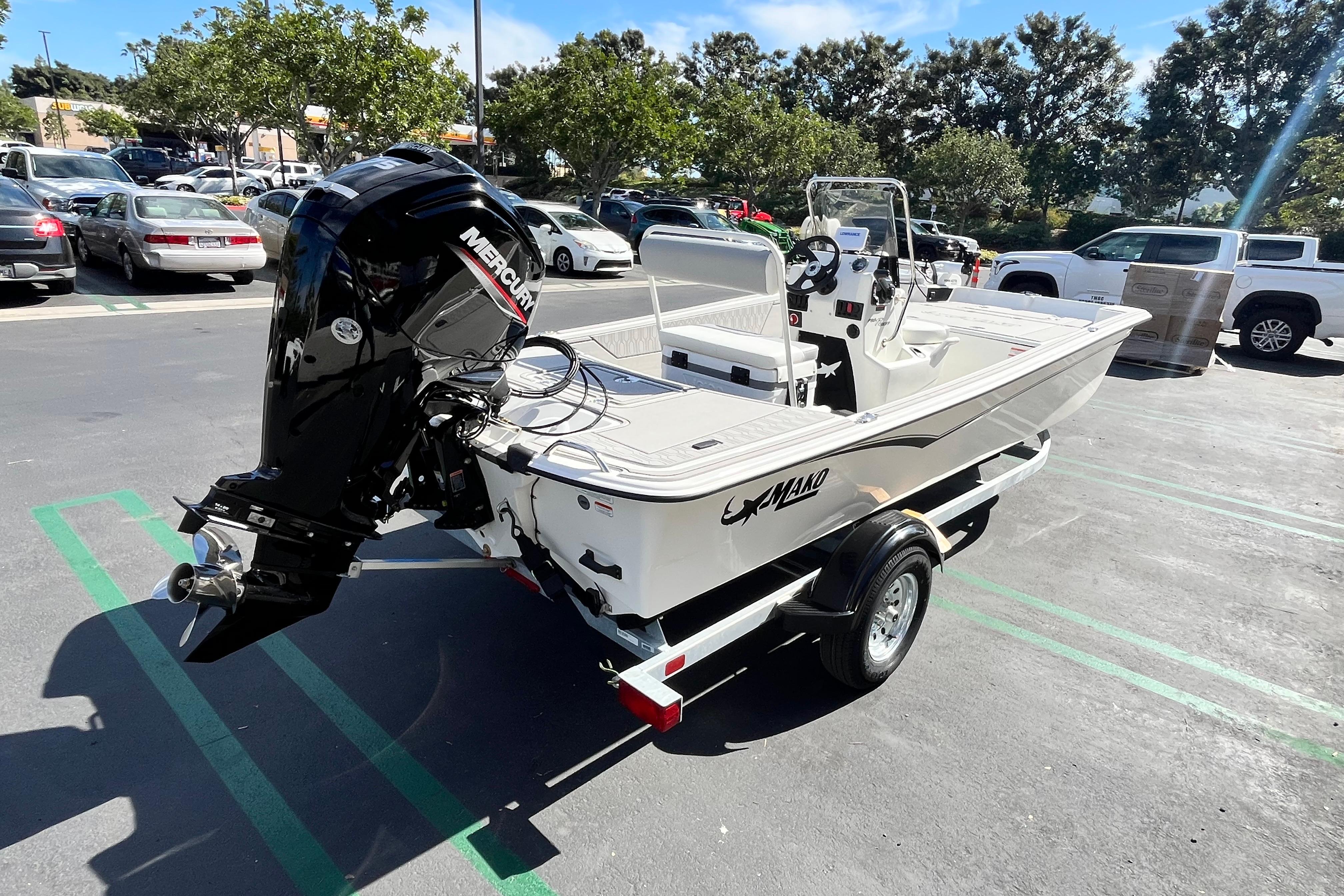 2026 Mako Pro Skiff 17 CC boat on trailer in parking lot, featuring Mercury outboard motor.