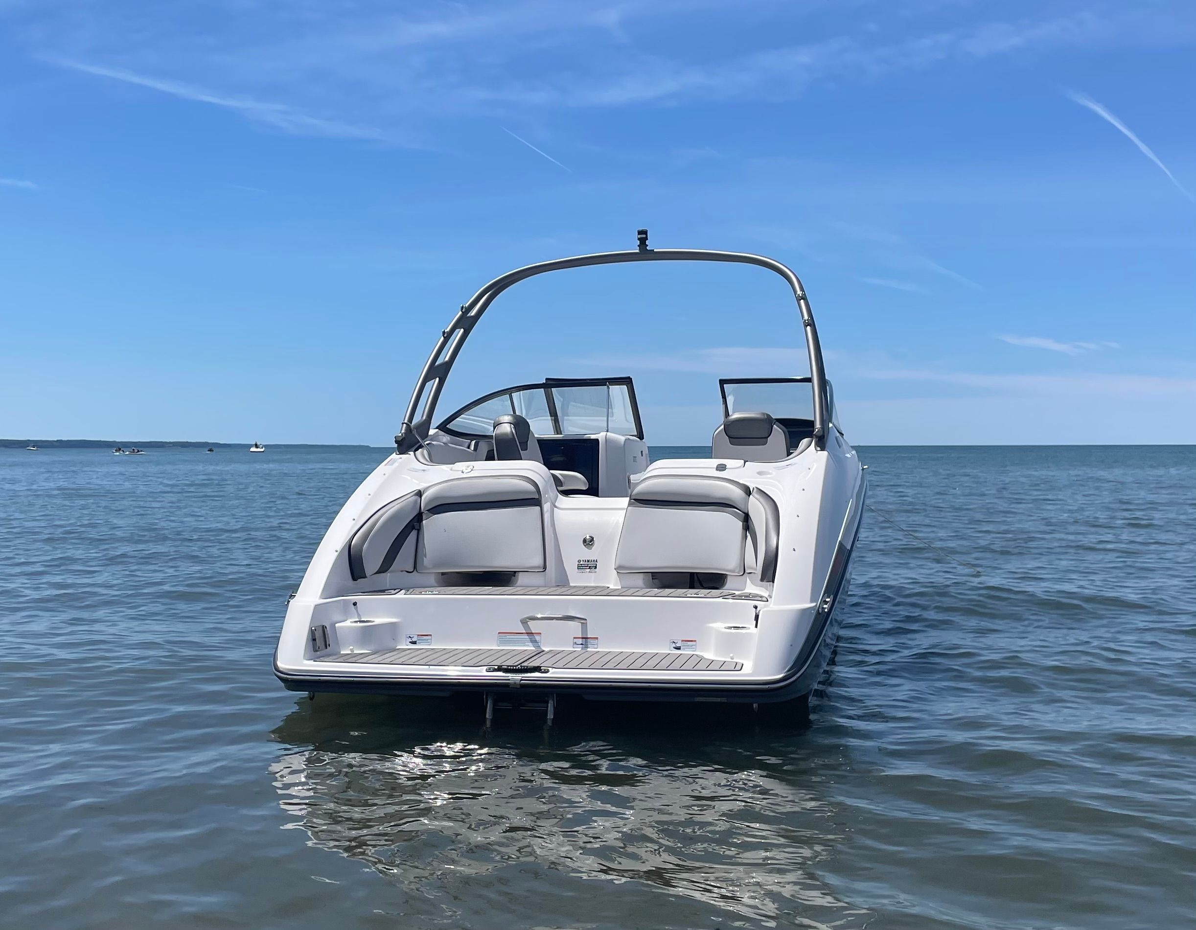A 2019 Yamaha AR240 boat floats on calm water under a blue sky.
