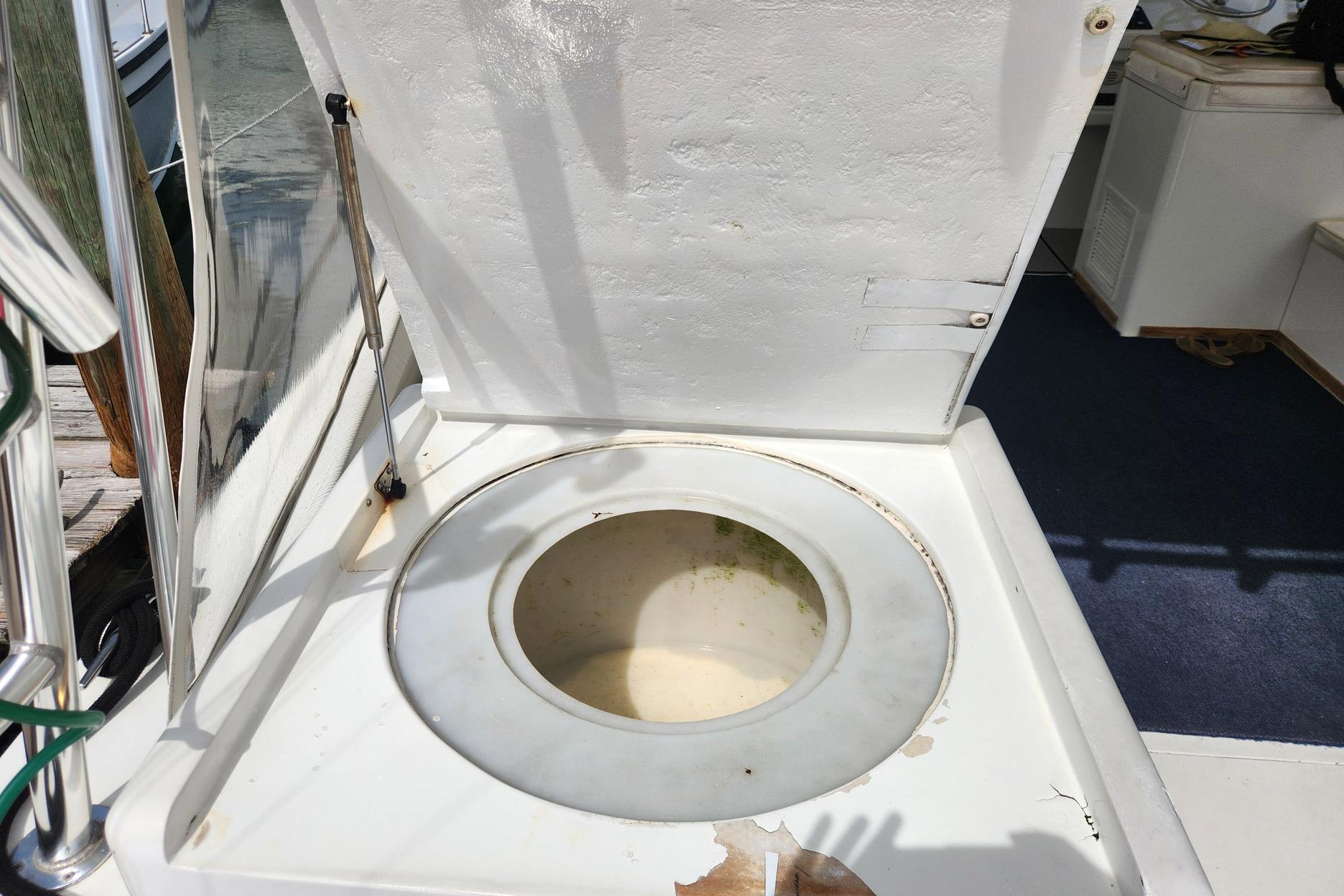 Open hatch on 1987 Young Brothers Custom Sport Fish boat, revealing storage compartment.