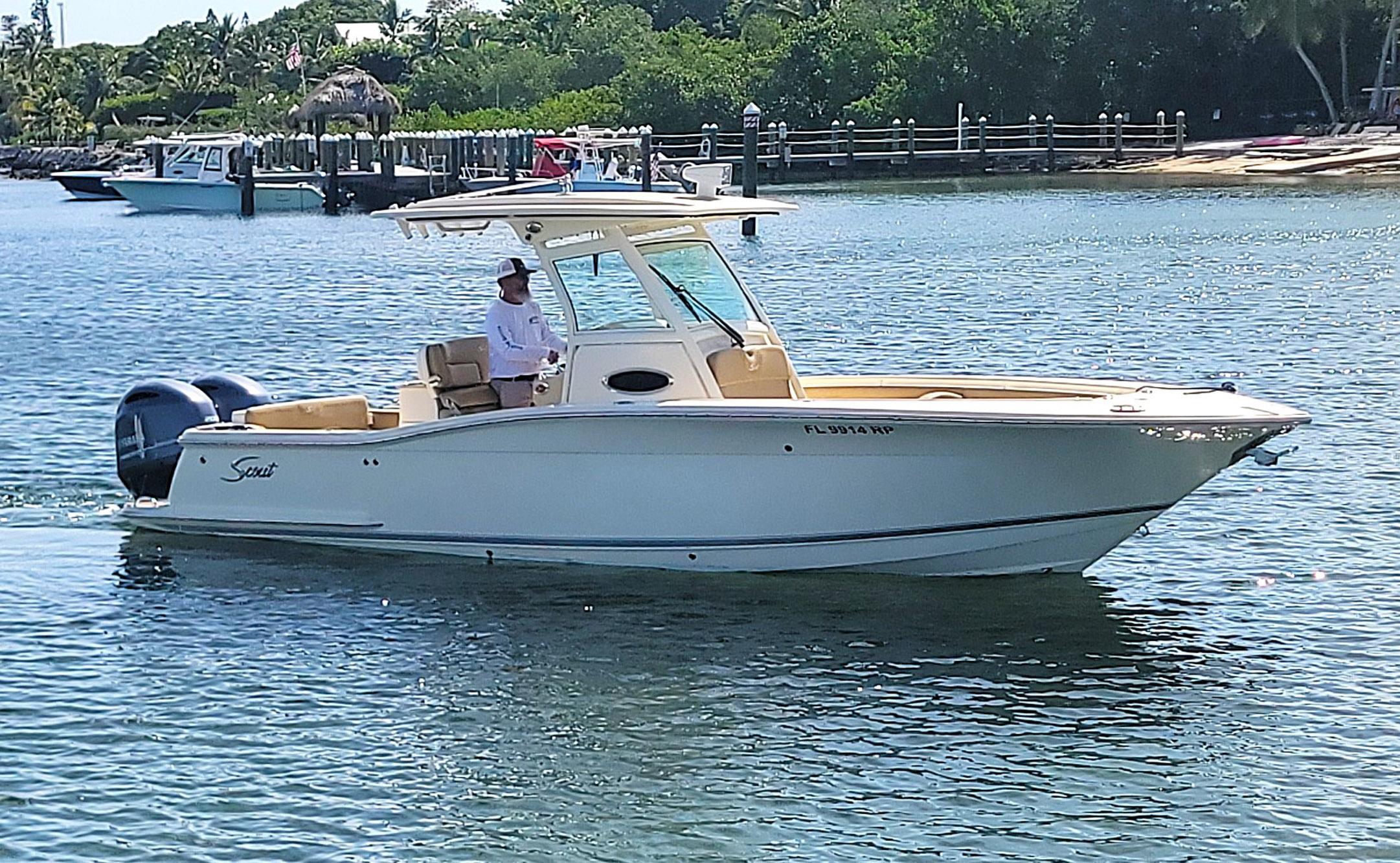 2018 Scout 275 LXF boat cruising on a sunny day in calm waters.