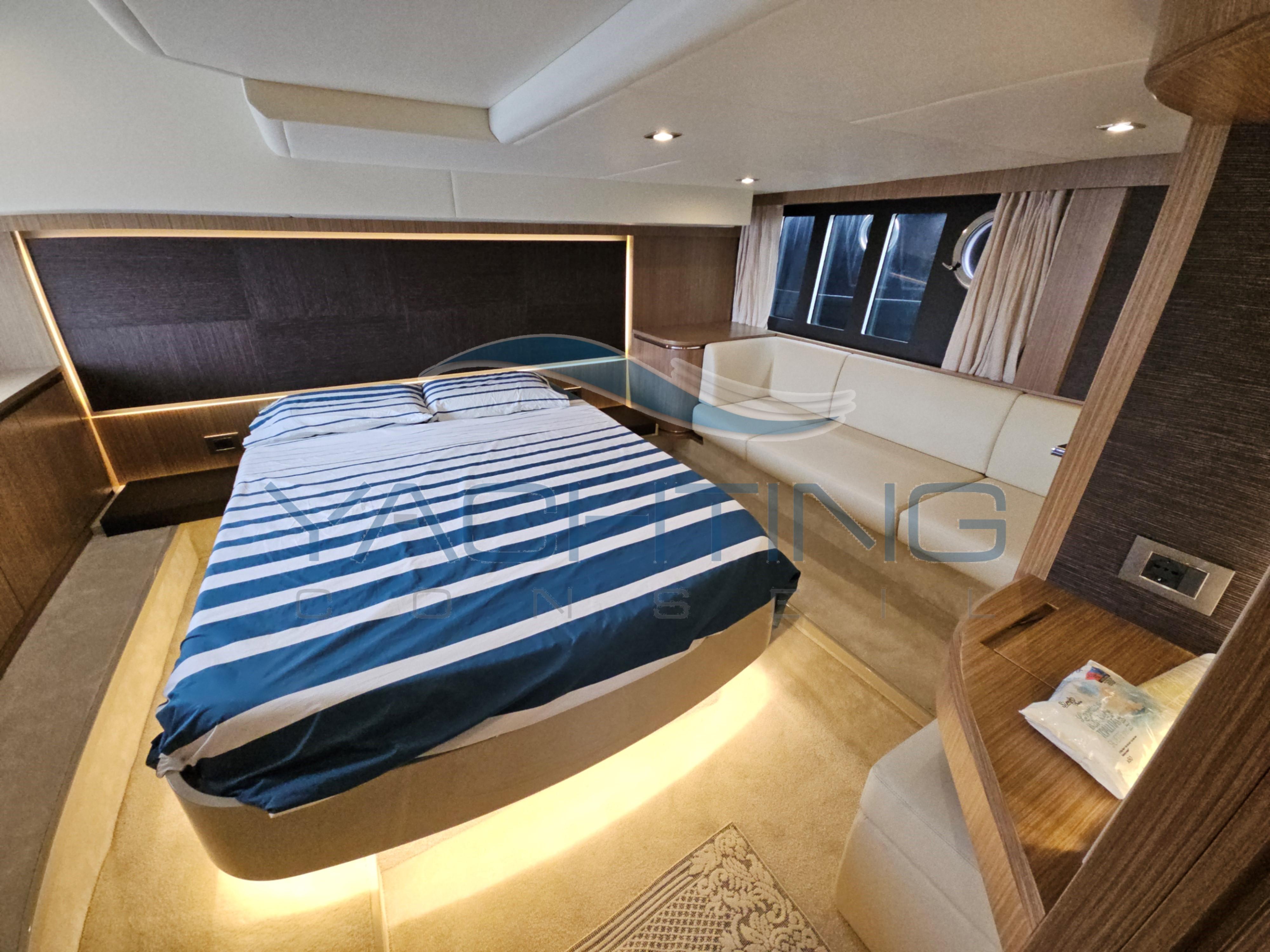 Luxurious cabin interior of 2018 Absolute 45 FLY yacht with striped bedding.
