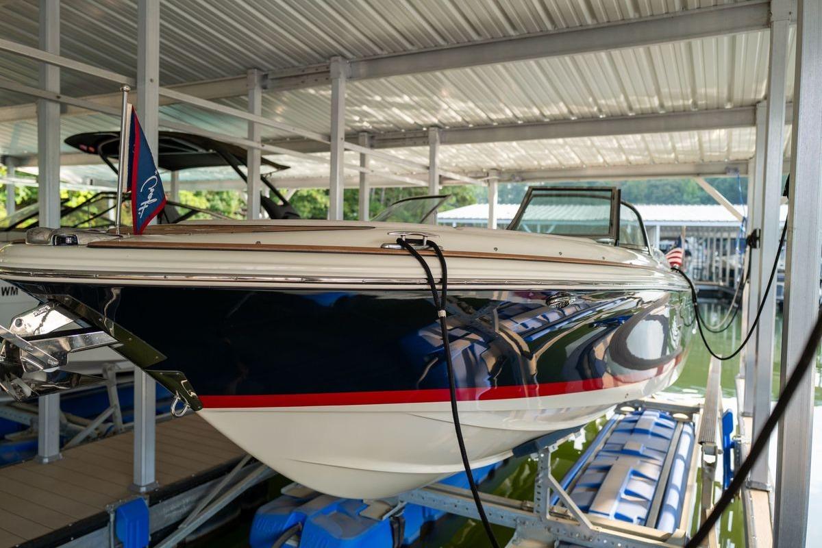 2023 Chris-Craft Launch 27 boat docked under a covered marina.