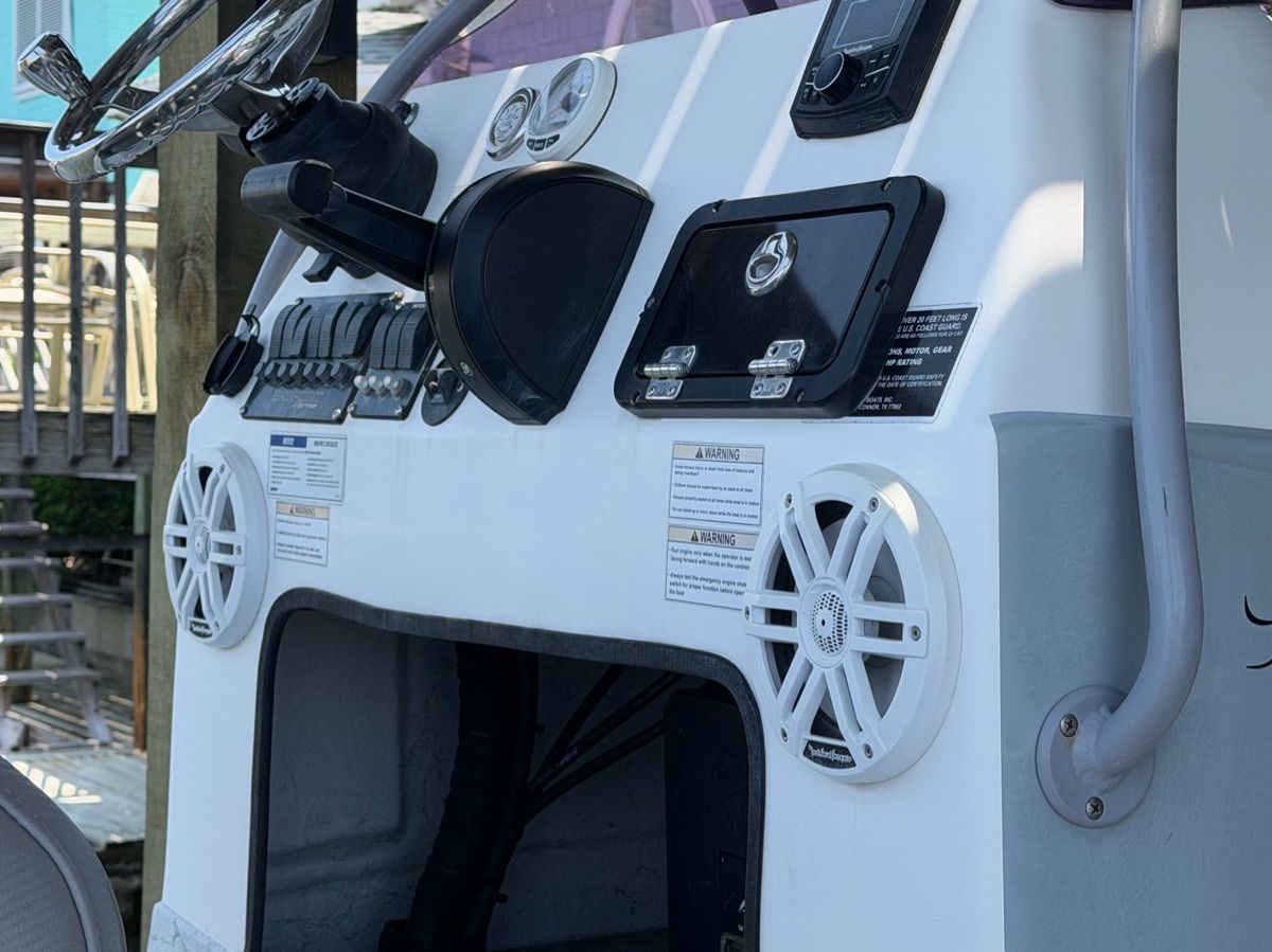 The image shows the helm of a 2022 Shoalwater 23' Catamaran with instruments and speakers.