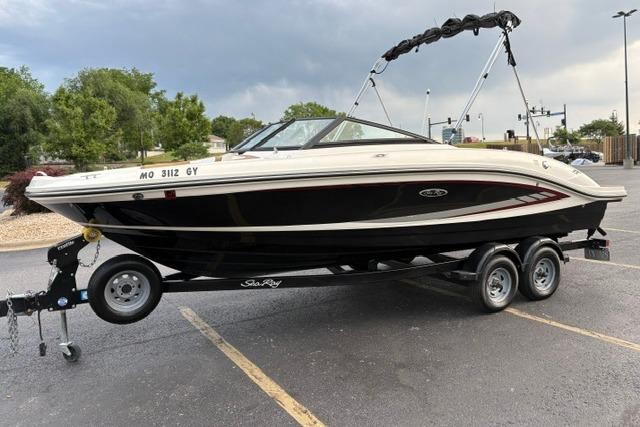 2017 Searay SPX210 boat on trailer in parking lot, overcast sky.