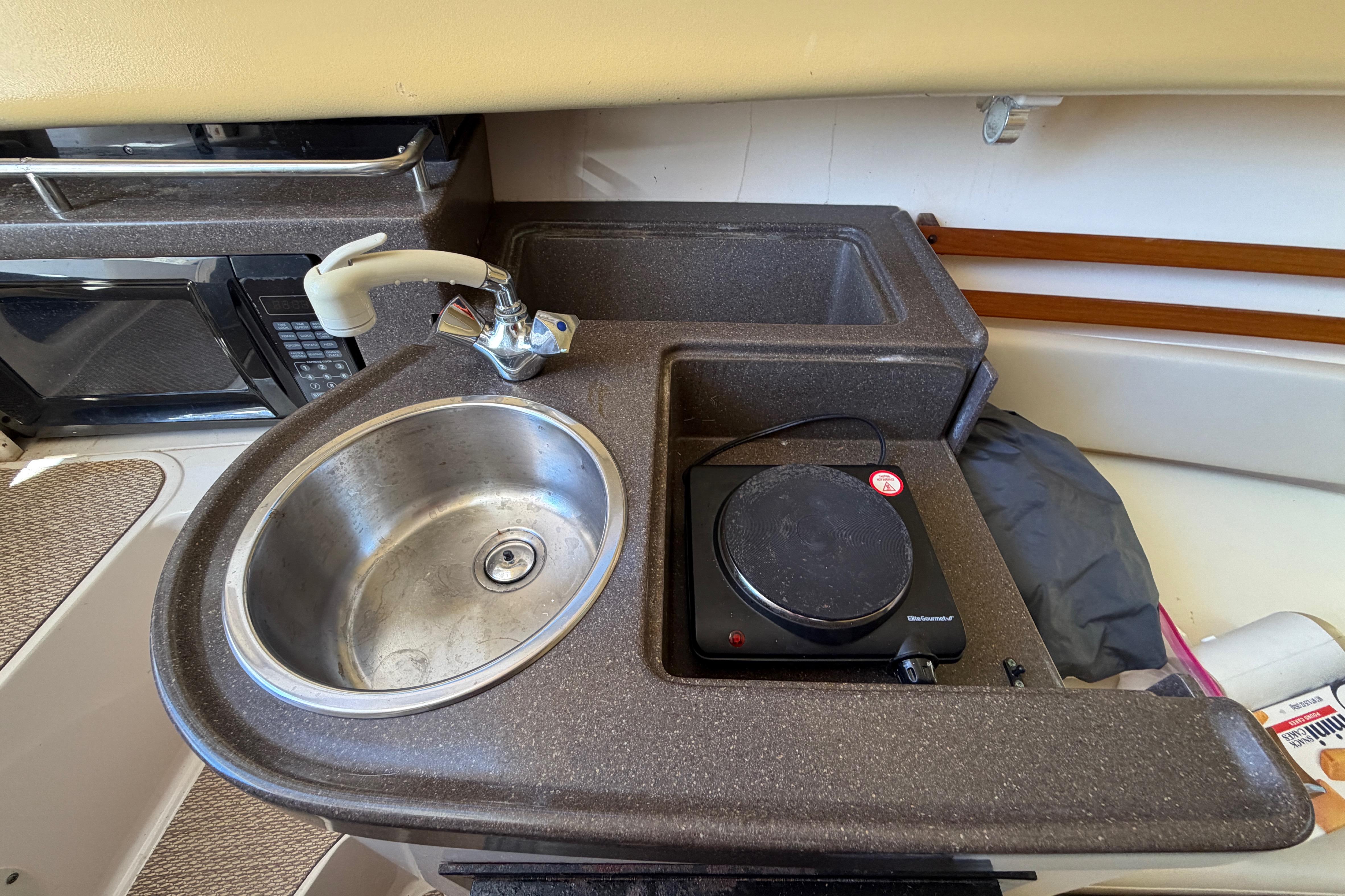 2006 Grady-White Sailfish 282 boat kitchenette with sink, faucet, and hot plate.