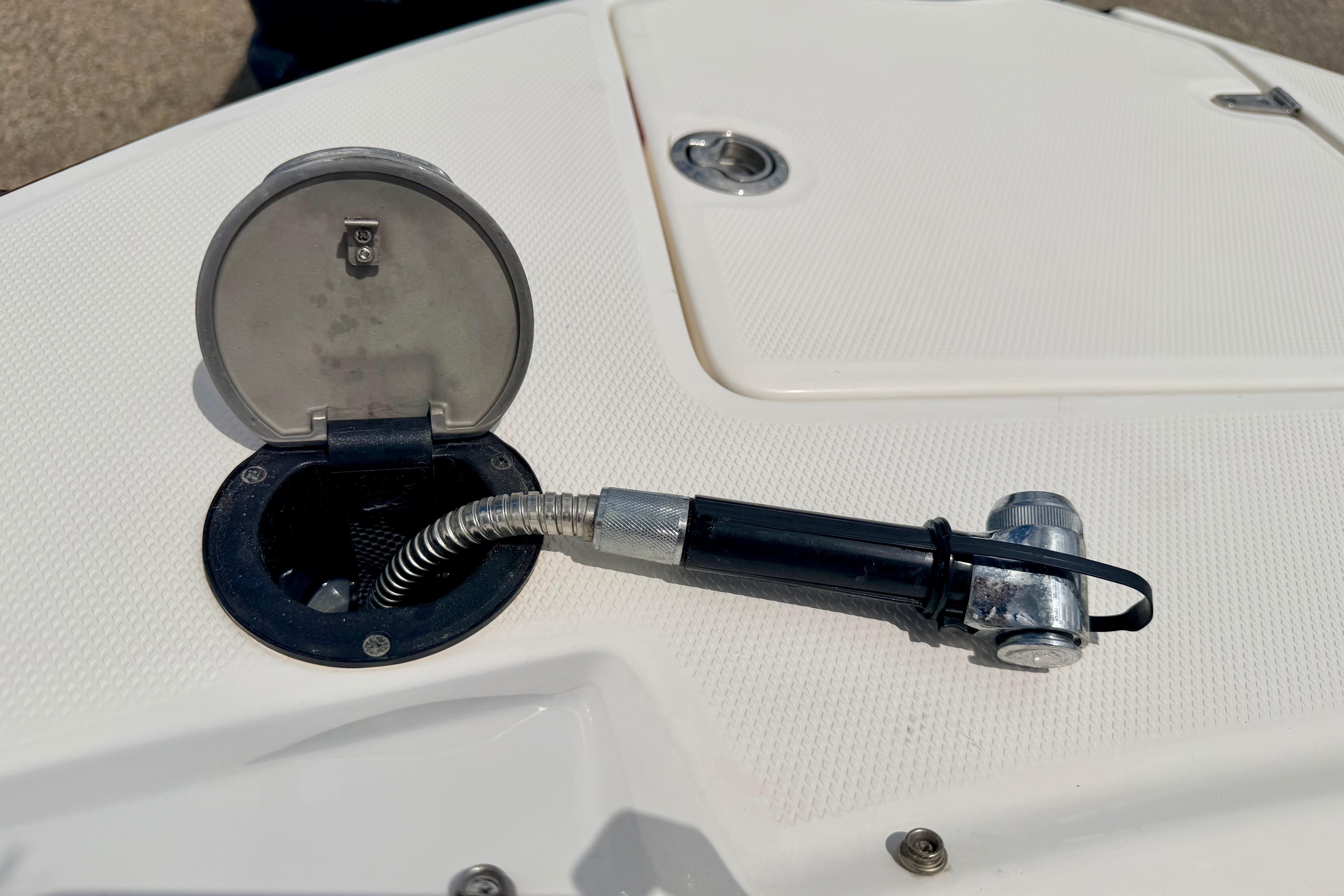2015 Chaparral Sunesta 264 boat deck with open hatch and hose attachment.