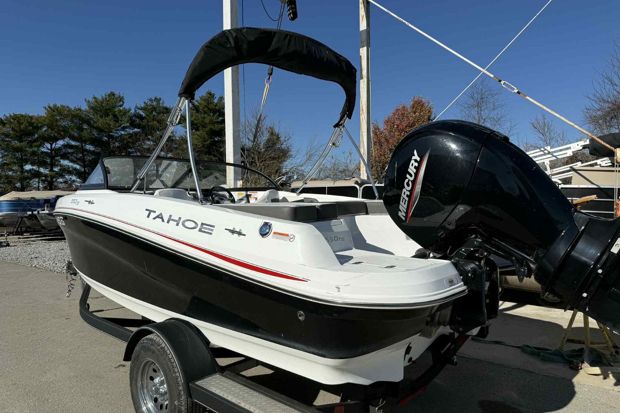2021 Tahoe 550 TS boat with Mercury engine on trailer, outdoors.
