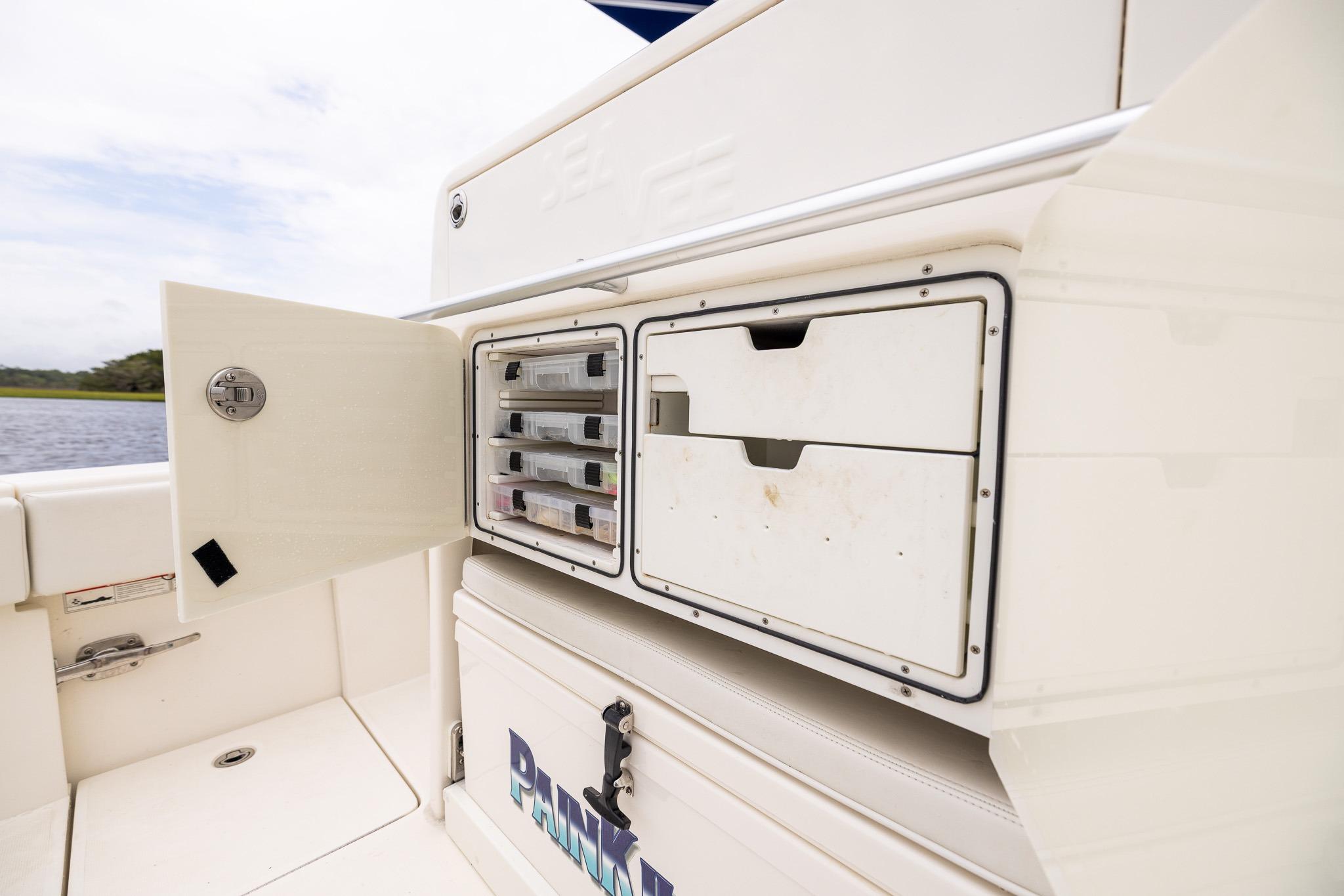 2019 SeaVee 322Z boat storage compartment with organized tackle boxes and drawers.
