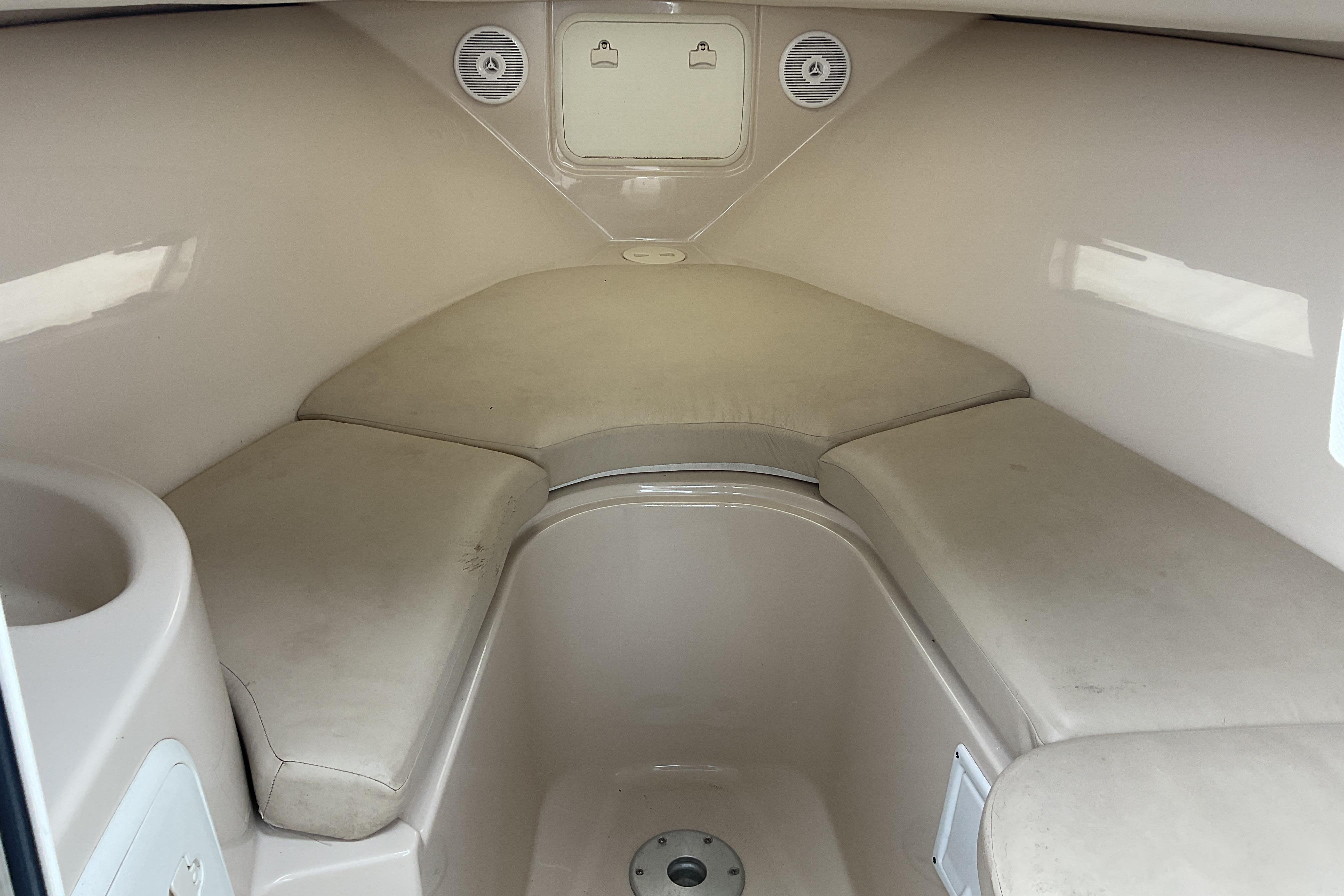 Interior cabin of 2012 Wellcraft 232 Coastal boat, featuring cushioned seating.