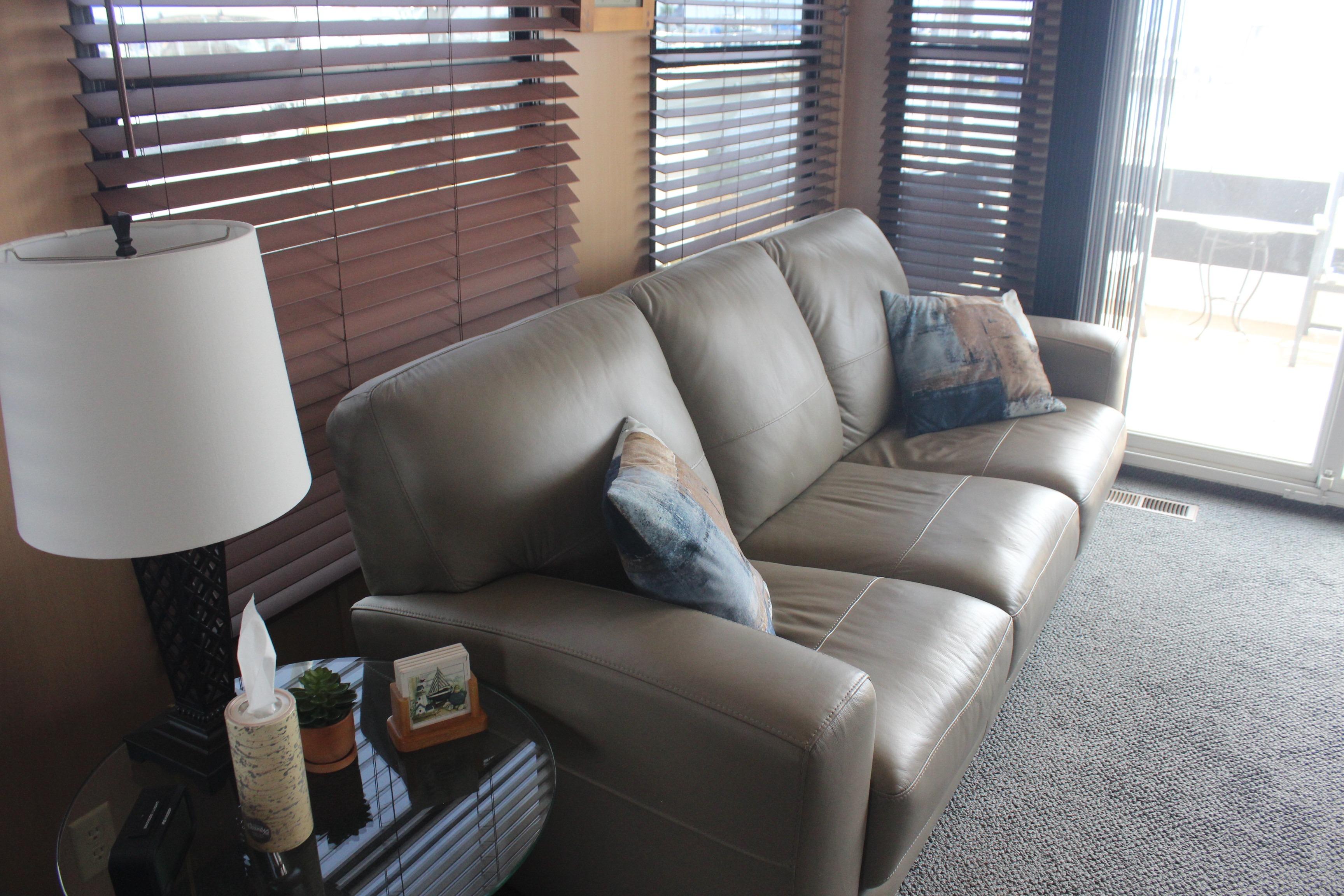 Luxurious interior of 2010 Skipperliner 480 Flybridge with leather sofa and decorative pillows.