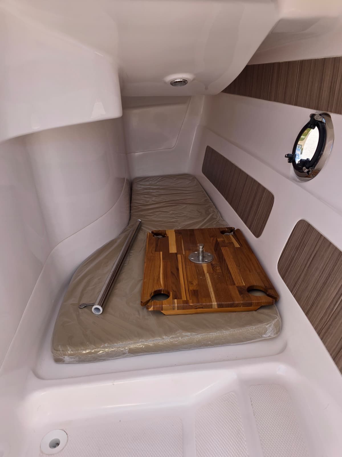 Interior of a Coral 26 with cushion and wooden table.