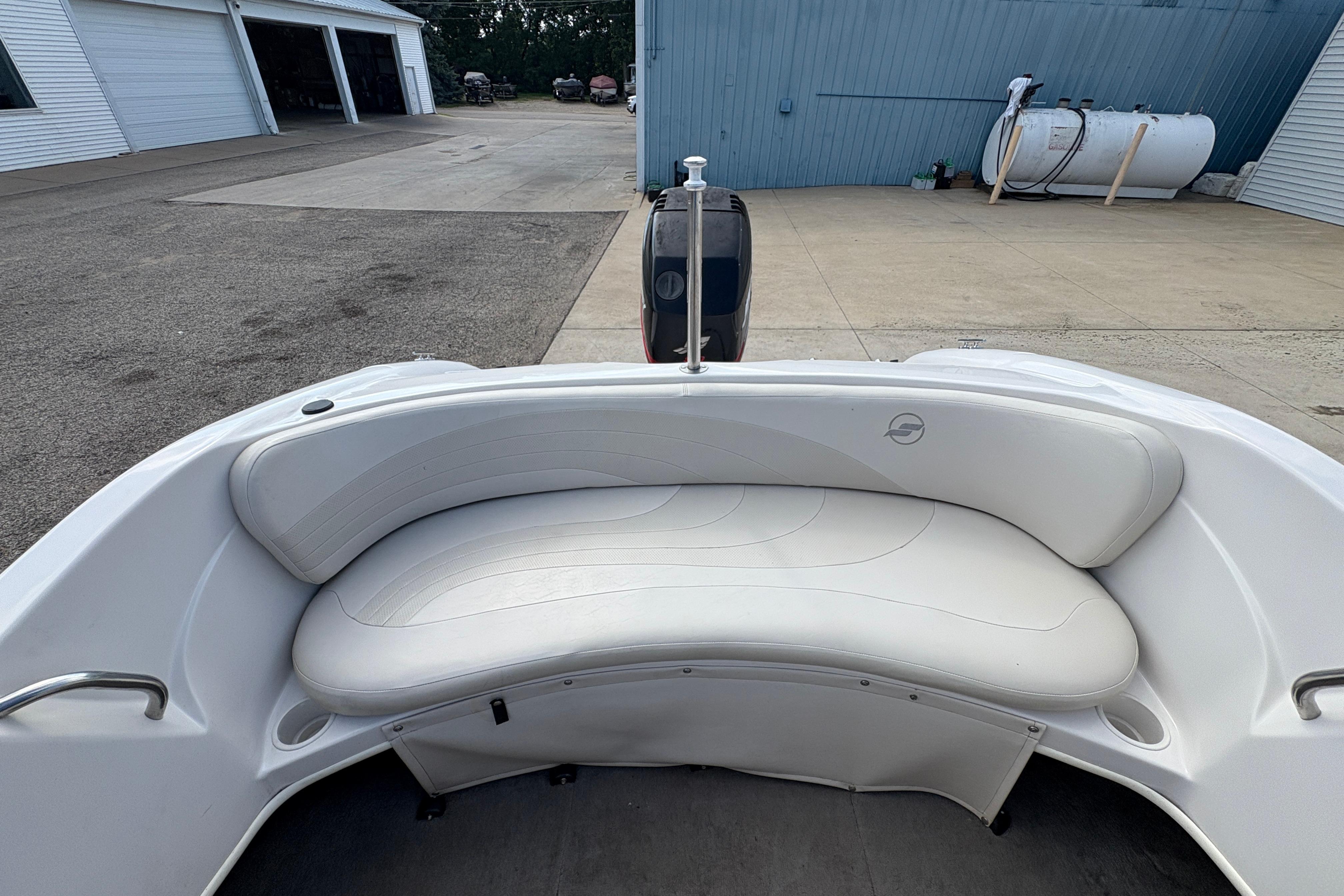 2005 Starcraft C-Star 1700 OB boat with white cushioned seating in a marina setting.