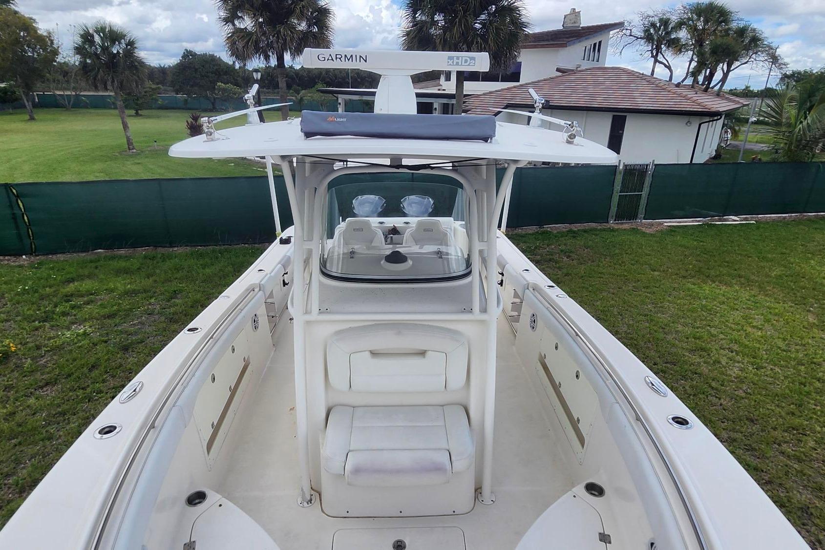 2015 Robalo R300 Center Console boat with Garmin equipment, docked on grassy area.
