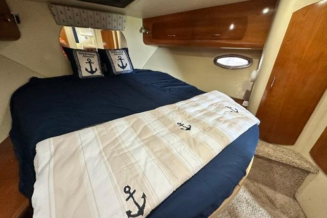 Luxurious cabin interior of 2004 Carver 360 Mariner with nautical-themed bedding.