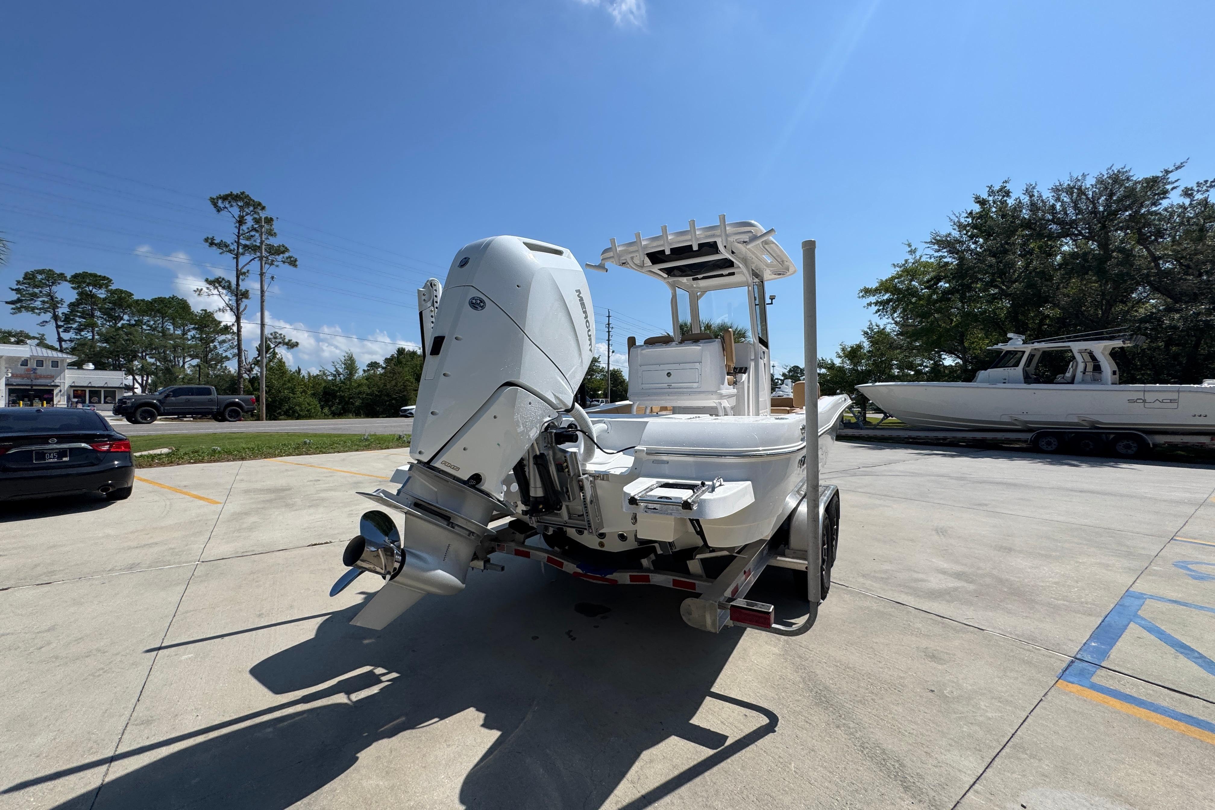 2027 Caymas 26 HB boat on trailer, parked outdoors under clear blue sky.